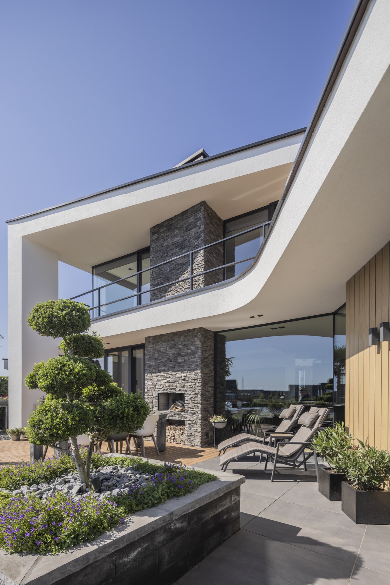 villa moderna sul lungomare: facciata e terrazza di Villa Miami con pilastro in pietra naturale e bordo del balcone curvo, Luxury, Design, Exclusive, Modern, Custom Made, Special, Beautiful