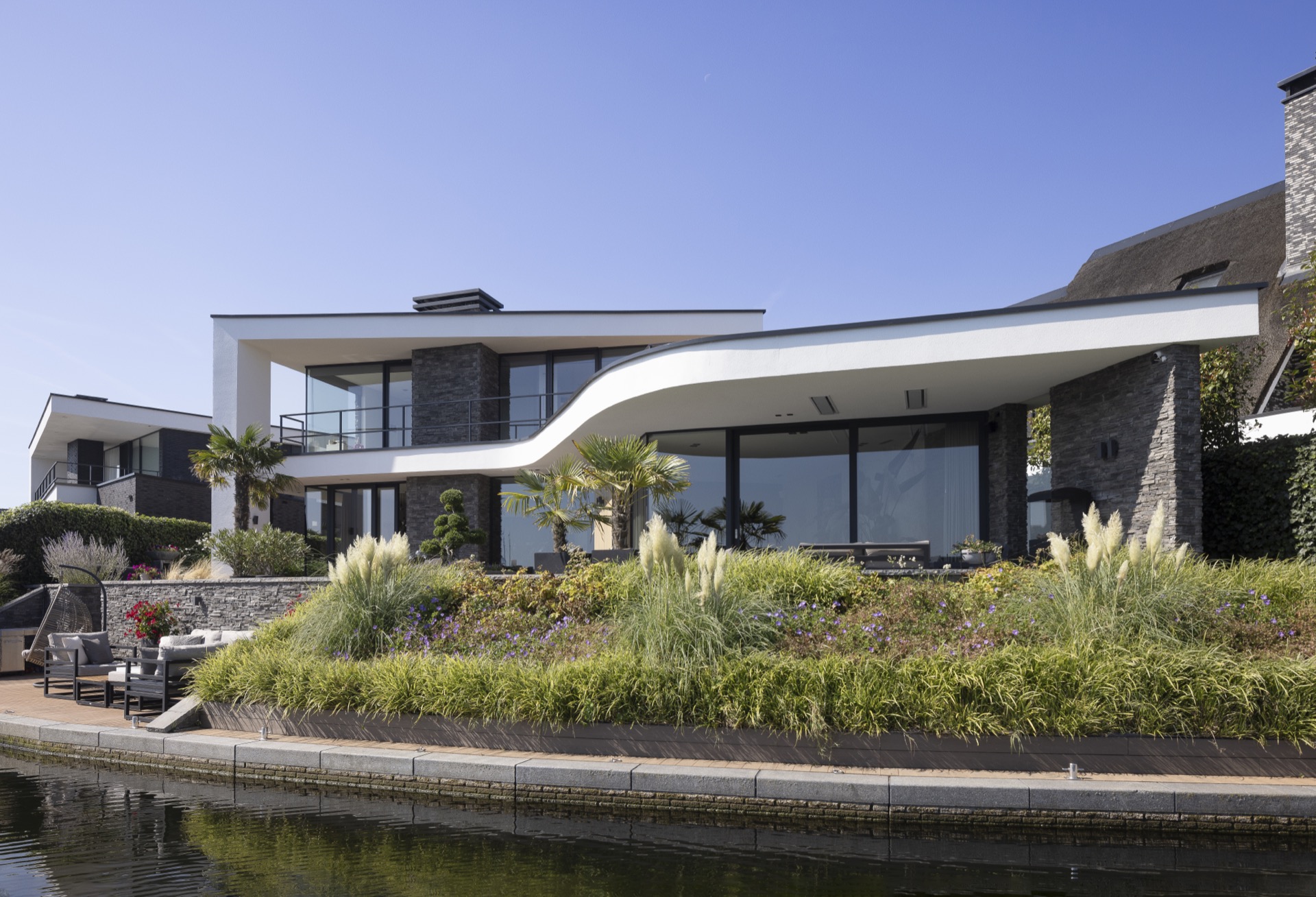 villa moderna sul lungomare: vista della facciata di Villa Miami con pietra naturale, doghe in legno e ingresso, Luxury, Design, Exclusive, Modern, Custom Made, Special, Beautiful