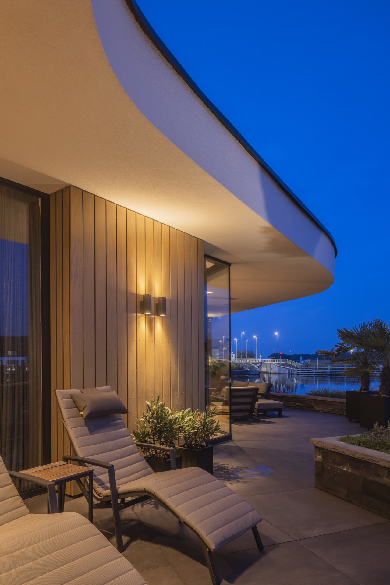 villa moderna sul lungomare: patio d’ingresso di notte a Villa Miami con parete in pietra naturale e tettuccio curvo, Luxury, Design, Exclusive, Modern, Custom Made, Special, Beautiful