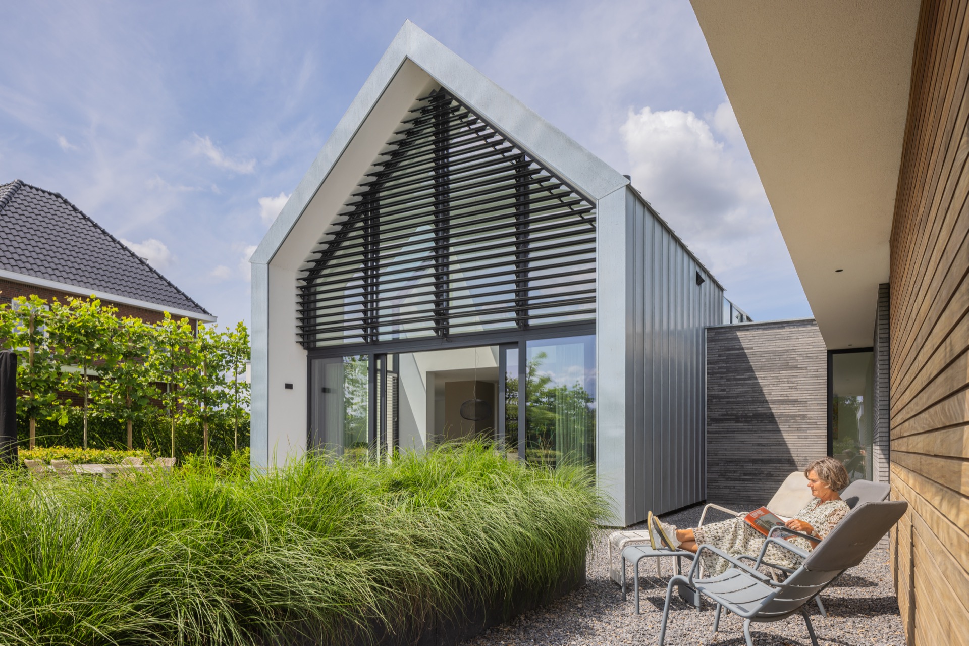 villa con accento facciata tipo zinco: facciata laterale con lamelle sopra grandi porte in vetro e una moderna tettoia bianca, Luxe, Design, Exclusief, Modern, Maatwerk, Bijzondere, Mooie