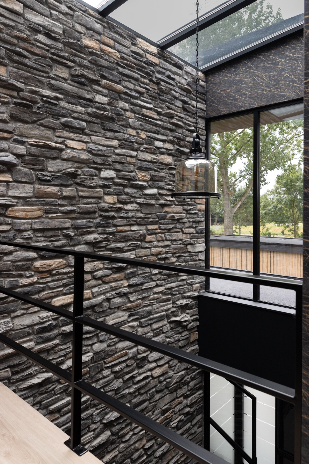 modern home natural stone strip cladding: hanging lamp with glass shade by a natural stone wall and a large window opening, Luxe, Design, Exclusief, Modern, Maatwerk, Bijzondere, Mooie