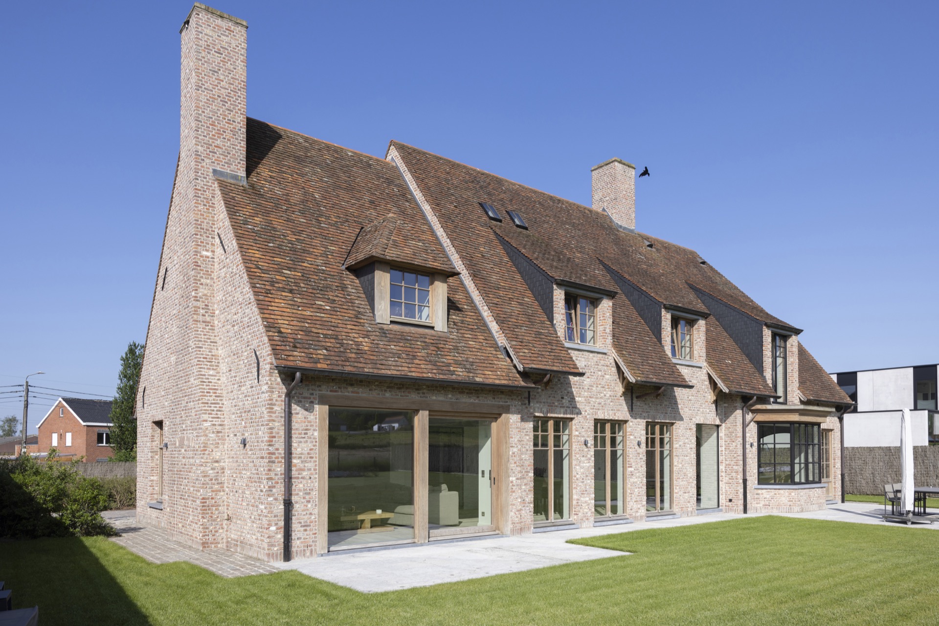 Afrormosia wood joinery project: facade view with brickwork, wooden frames, and windows under a steep tiled roof, Luxe, Design, Exclusief, Modern, Maatwerk, Bijzondere, Mooie
