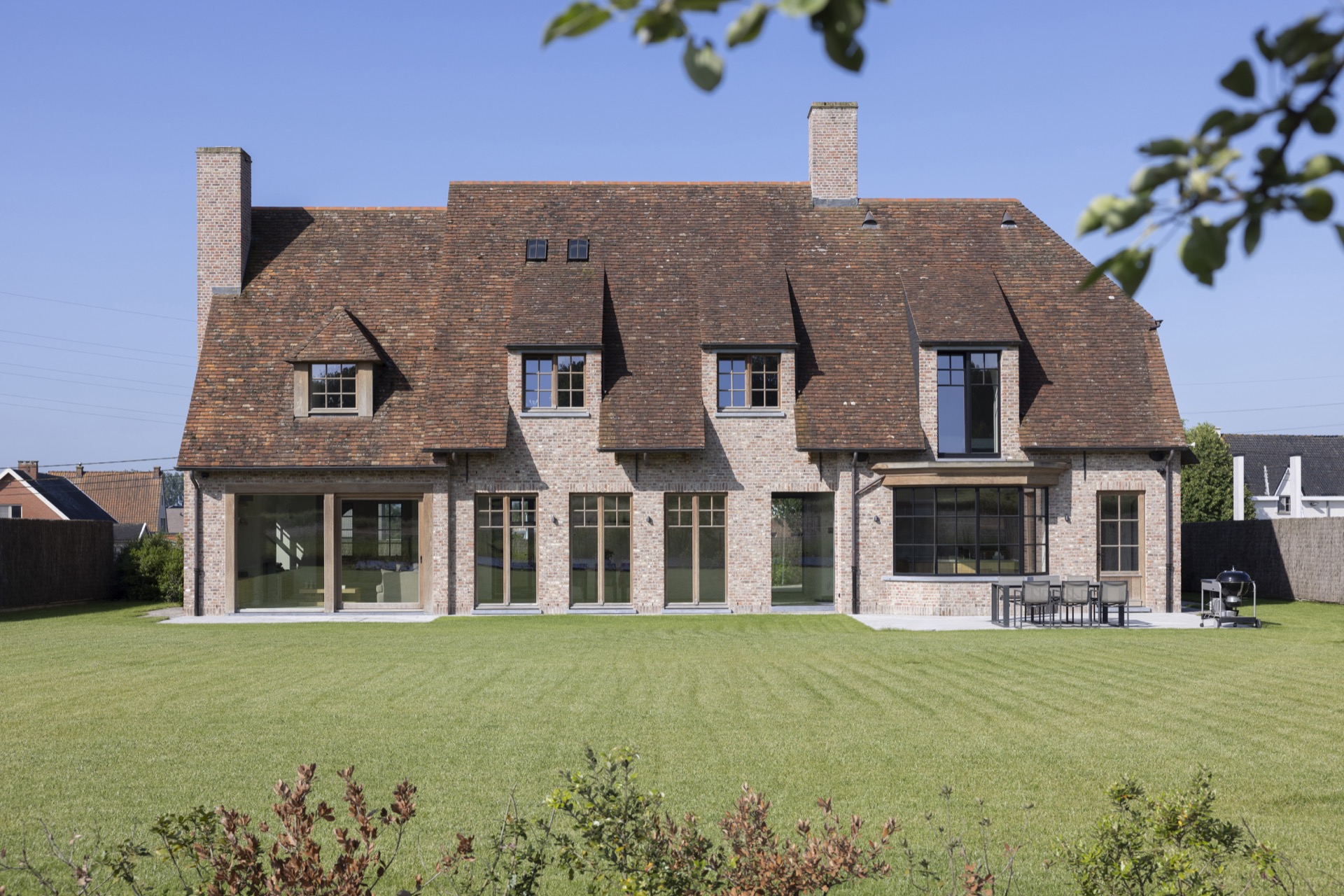 Afrormosia wood joinery project: villa exterior with brick facade, wooden windows, and large glass openings, Luxe, Design, Exclusief, Modern, Maatwerk, Bijzondere, Mooie