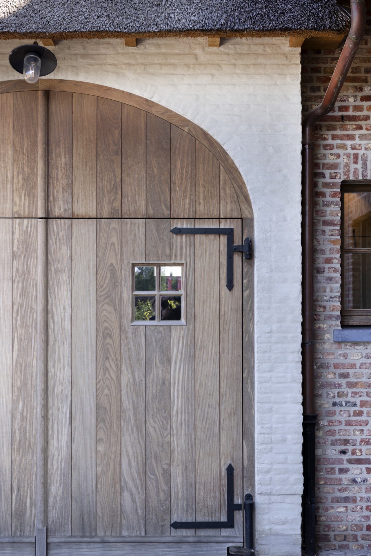 Afrormosia wood joinery project: detail of a arched wooden gate with brick surround and black hardware, Luxe, Design, Exclusief, Modern, Maatwerk, Bijzondere, Mooie