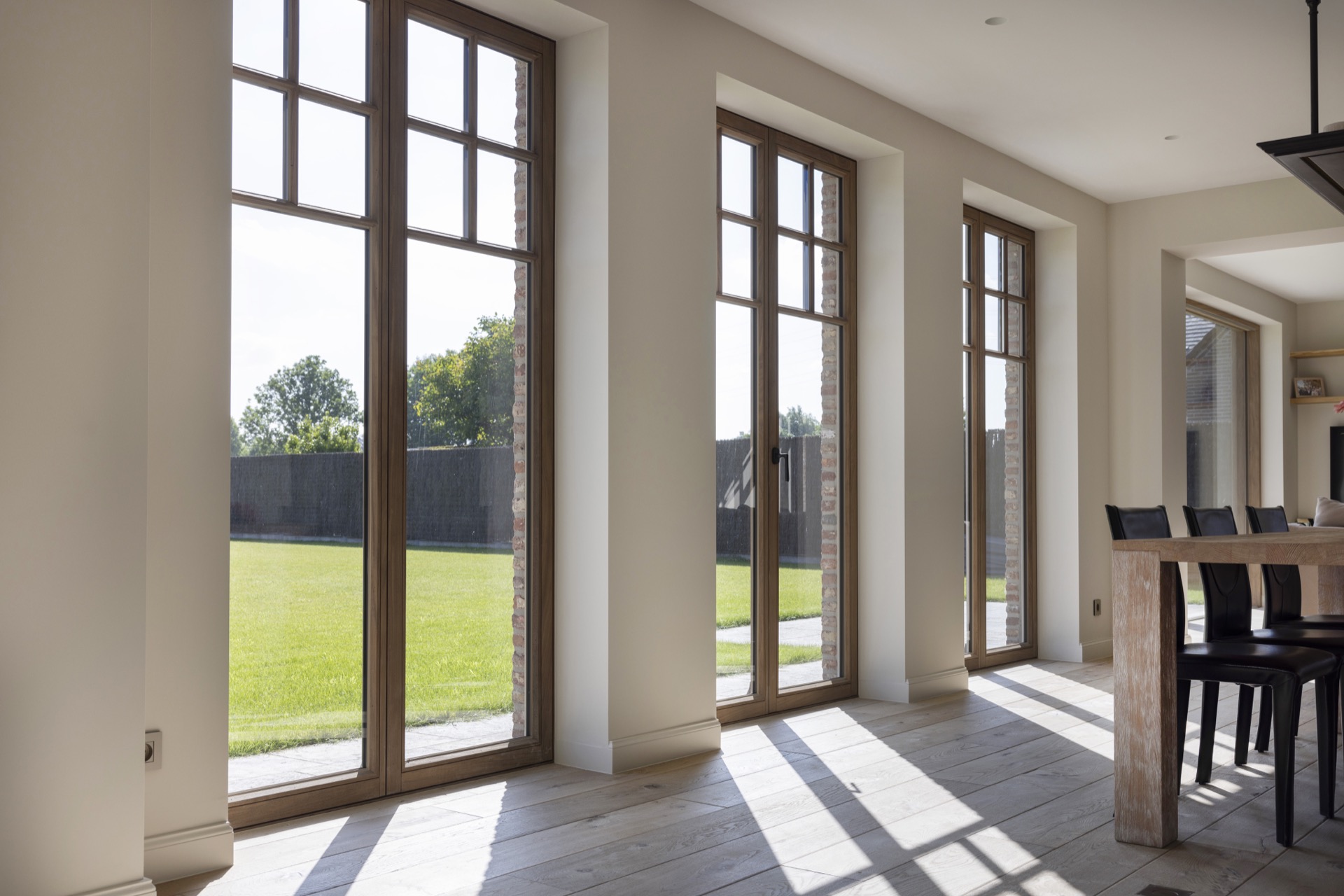 Afrormosia wood joinery project: interior view with tall wooden window frames and glass doors to the terrace, Luxe, Design, Exclusief, Modern, Maatwerk, Bijzondere, Mooie