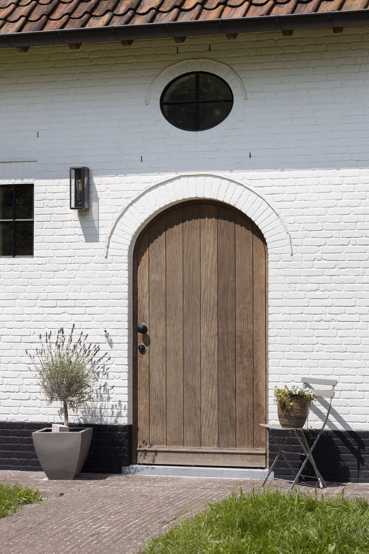 finestre in legno nero verniciato e porte esterne in legno naturale: porta d’ingresso in legno ad arco su facciata bianca, Luxury, Design, Exclusive, Modern, Custom Made, Special, Beautiful