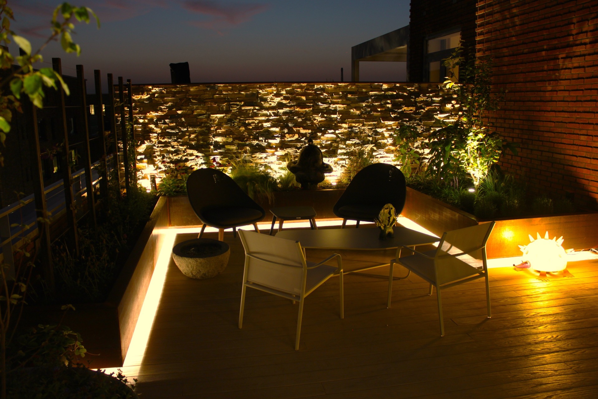 giardino pensile illuminazione: vista serale del giardino pensile con muro in pietra naturale illuminato e area relax vicino, Luxury, Design, Exclusive, Modern, Custom Made, Special, Beautiful