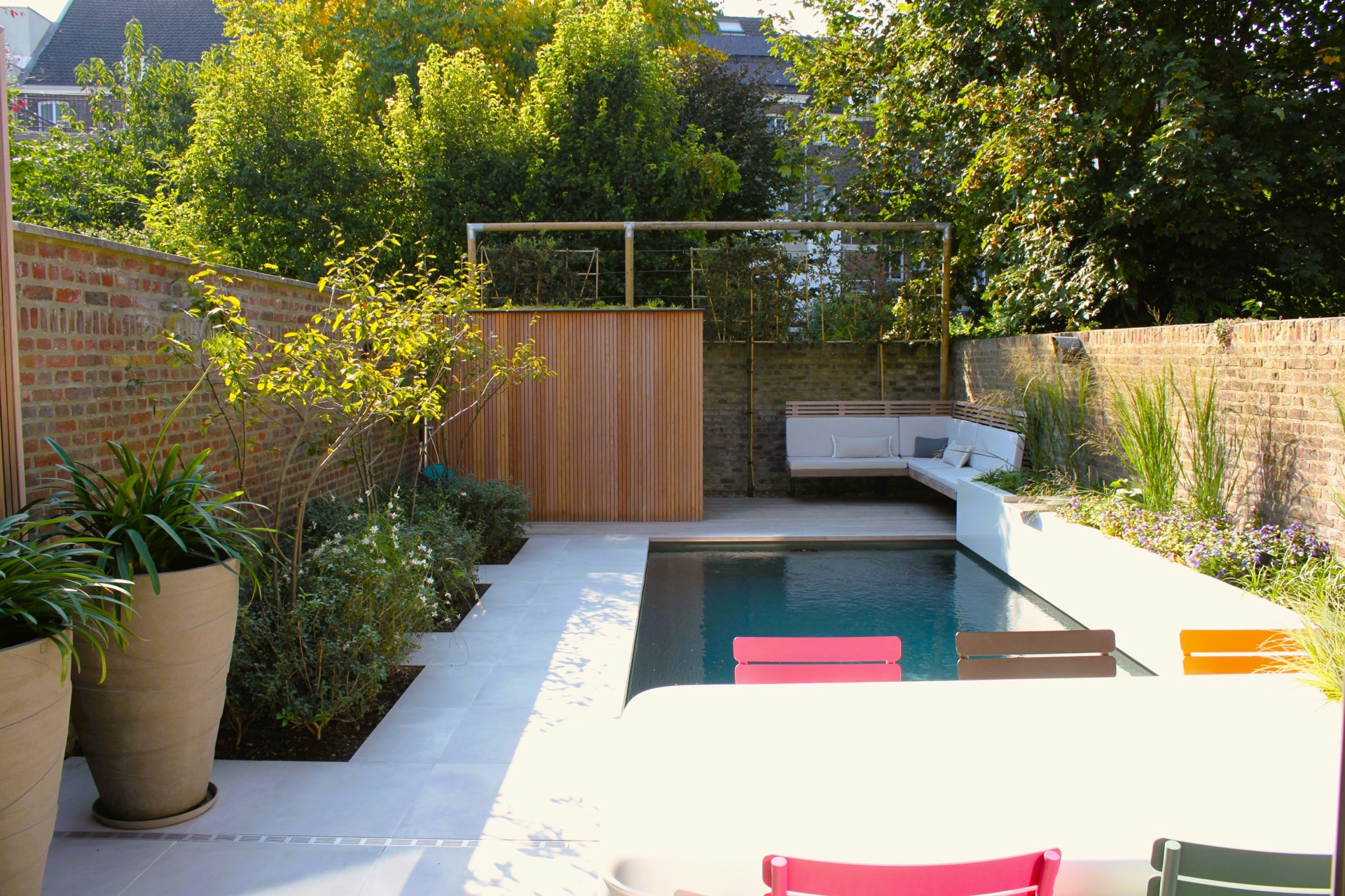 pool lounge area: patio garden with pool, terrace and lounge bench against a brick wall with wooden screen, Luxury, Design, Exclusive, Modern, Custom Made, Special, Beautiful