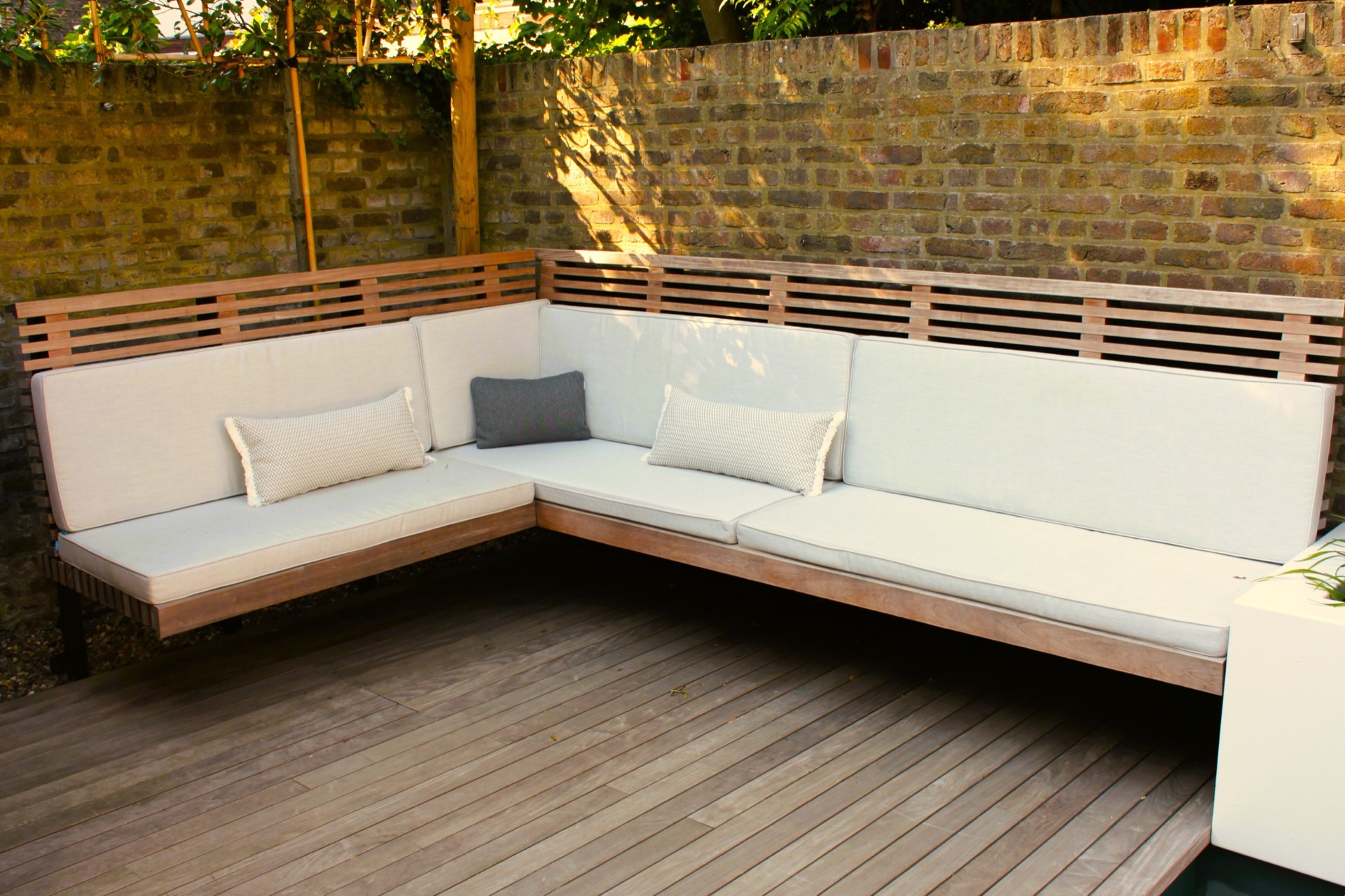 pool lounge area: corner lounge bench with white cushions and wooden frame along a brick wall in the garden, Luxury, Design, Exclusive, Modern, Custom Made, Special, Beautiful