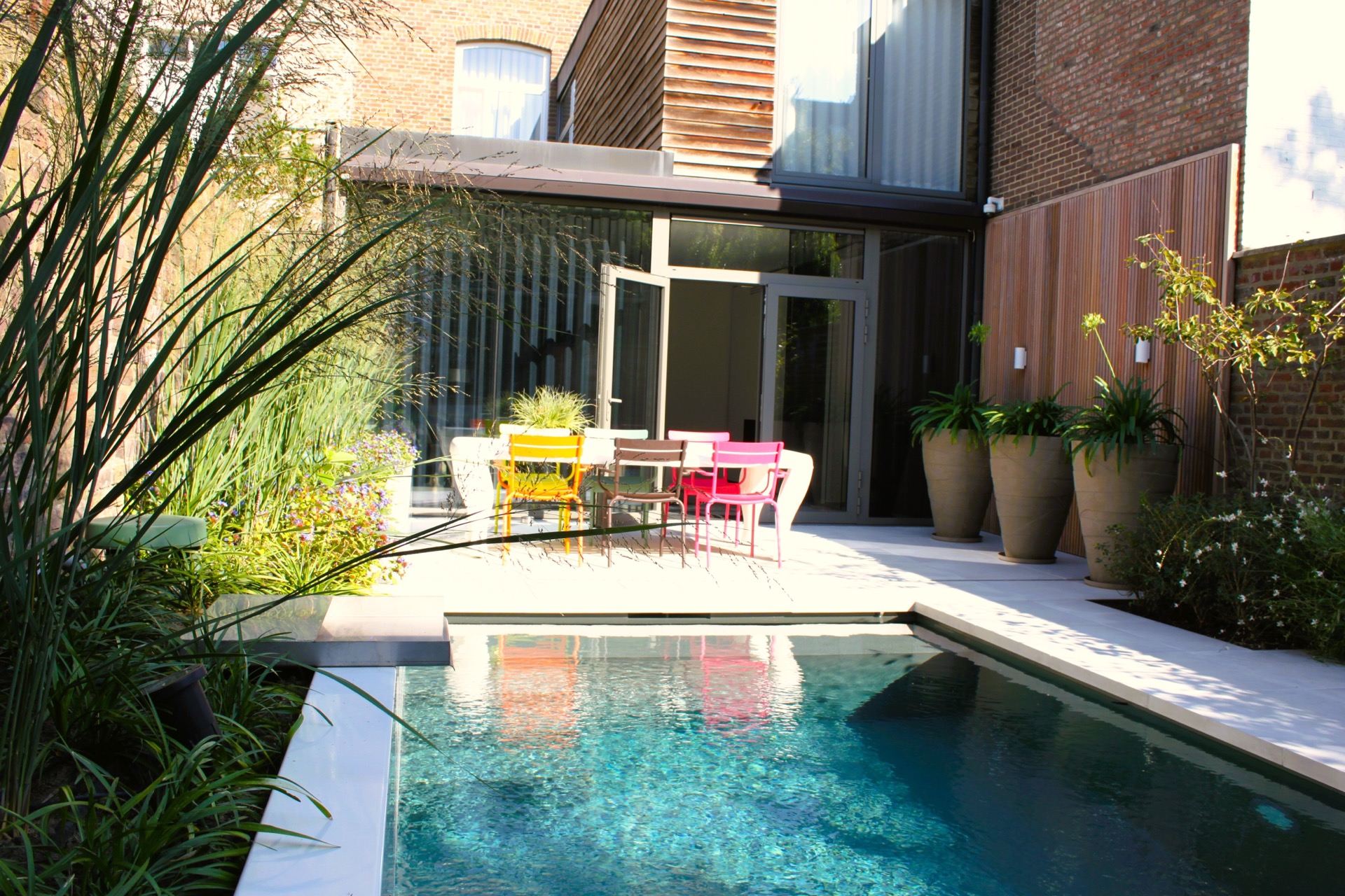 pool lounge area: side view of patio garden with glass openings, terrace and pool edge with lights along wood and brick, Luxury, Design, Exclusive, Modern, Custom Made, Special, Beautiful