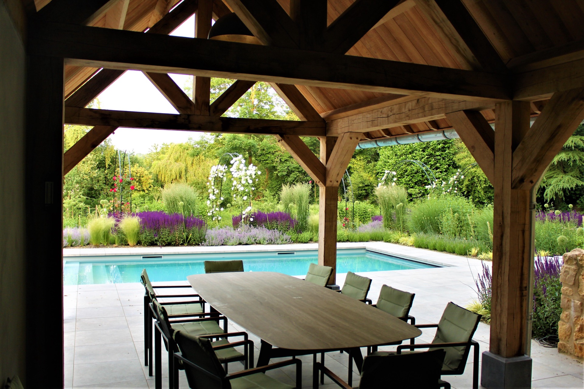 giardino paesaggistico inglese con piscina: sentiero in ghiaia simmetrico tra bordure viola davanti a un muro in pietra, Luxury, Design, Exclusive, Modern, Custom Made, Special, Beautiful