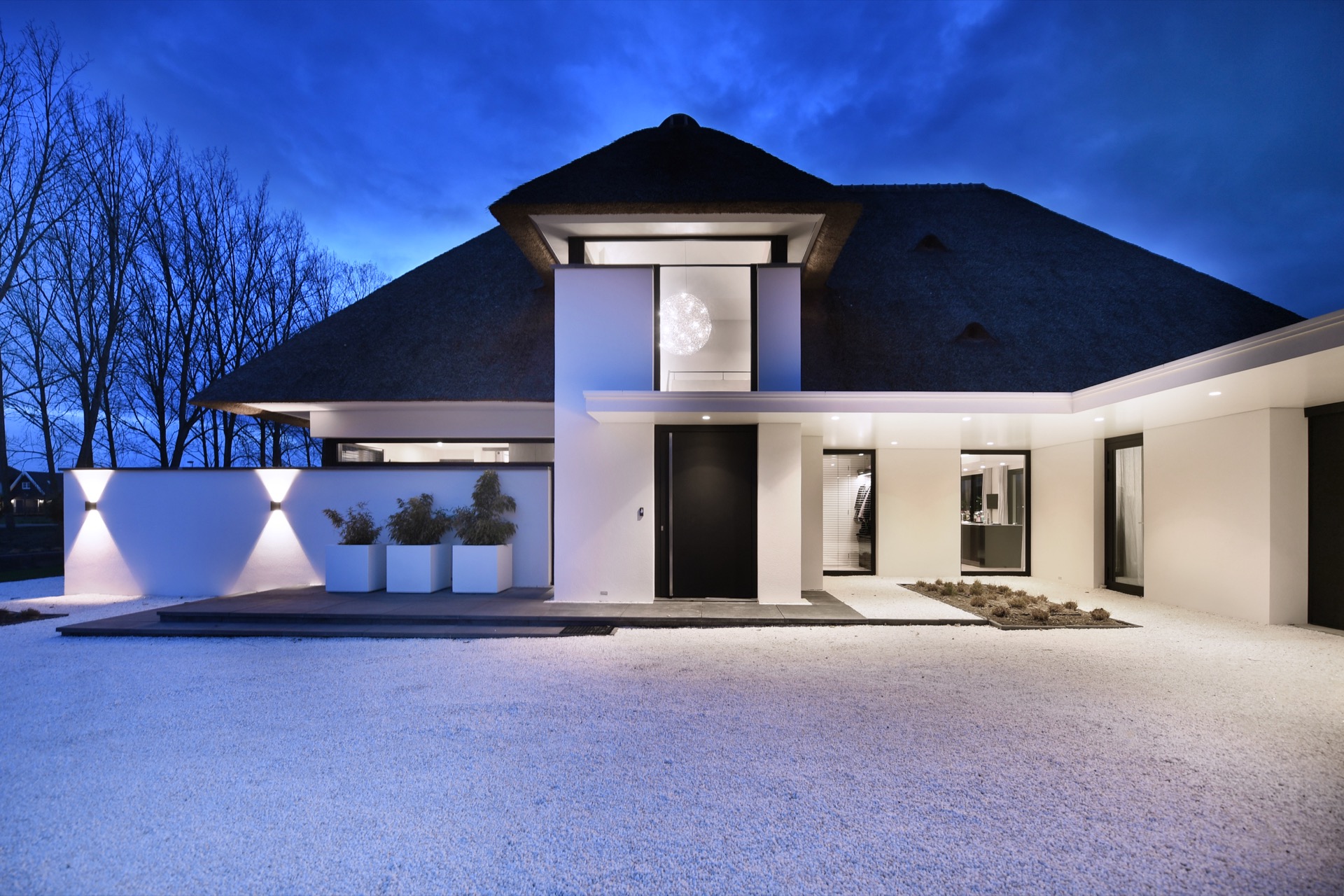 thatched roof craftsmanship: facade detail of a modern villa with thatched roof, white wall and illuminated entrance area, Luxe, Design, Exclusief, Modern, Maatwerk, Bijzondere, Mooie