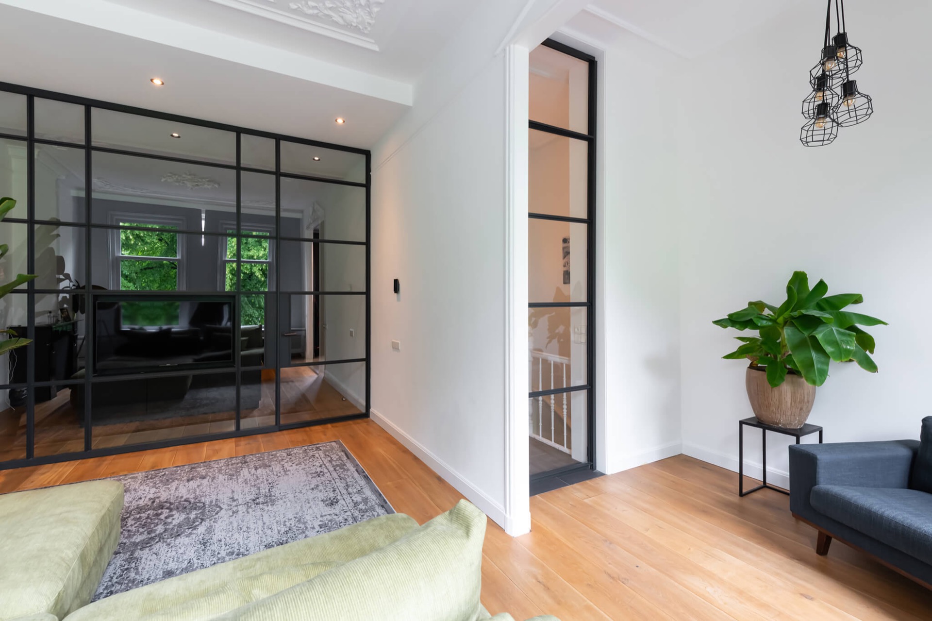 glass TV wall with hinged door: passage next to the glass cinewall with a black aluminum door frame and sightlines, Luxury, Design, Exclusive, Modern, Custom Made, Special, Beautiful