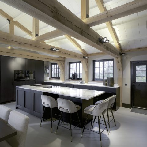 Intérieur de ferme unique : poutres en bois apparentes et sol taupe