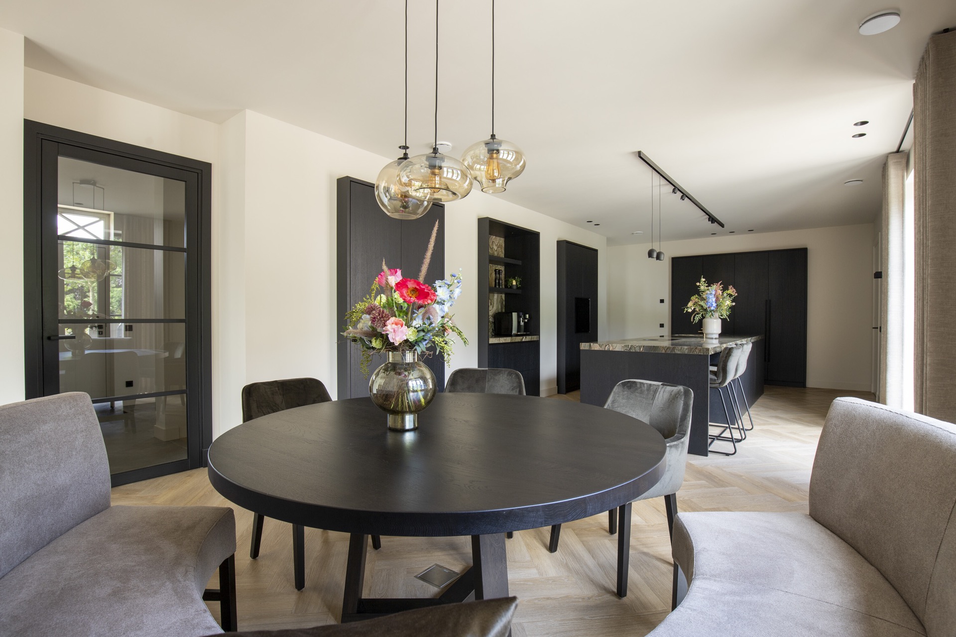 isola cucina con piano in pietra naturale: soggiorno open space con tavolo rotondo e luci a sospensione verso la cucina con, Luxury, Design, Exclusive, Modern, Custom Made, Special, Beautiful