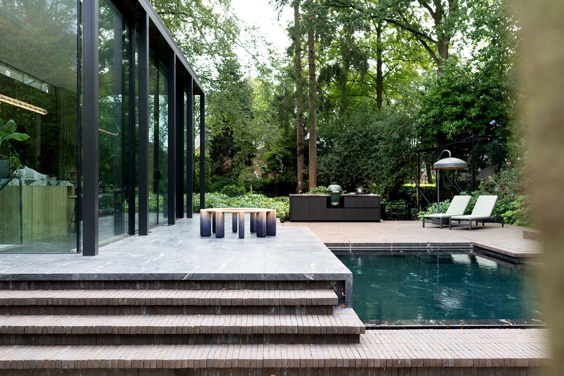 modern outdoor kitchen with natural stone worktop: inviting outdoor kitchen on a clean terrace with glass walls and a water, Luxury, Design, Exclusive, Modern, Custom Made, Special, Beautiful