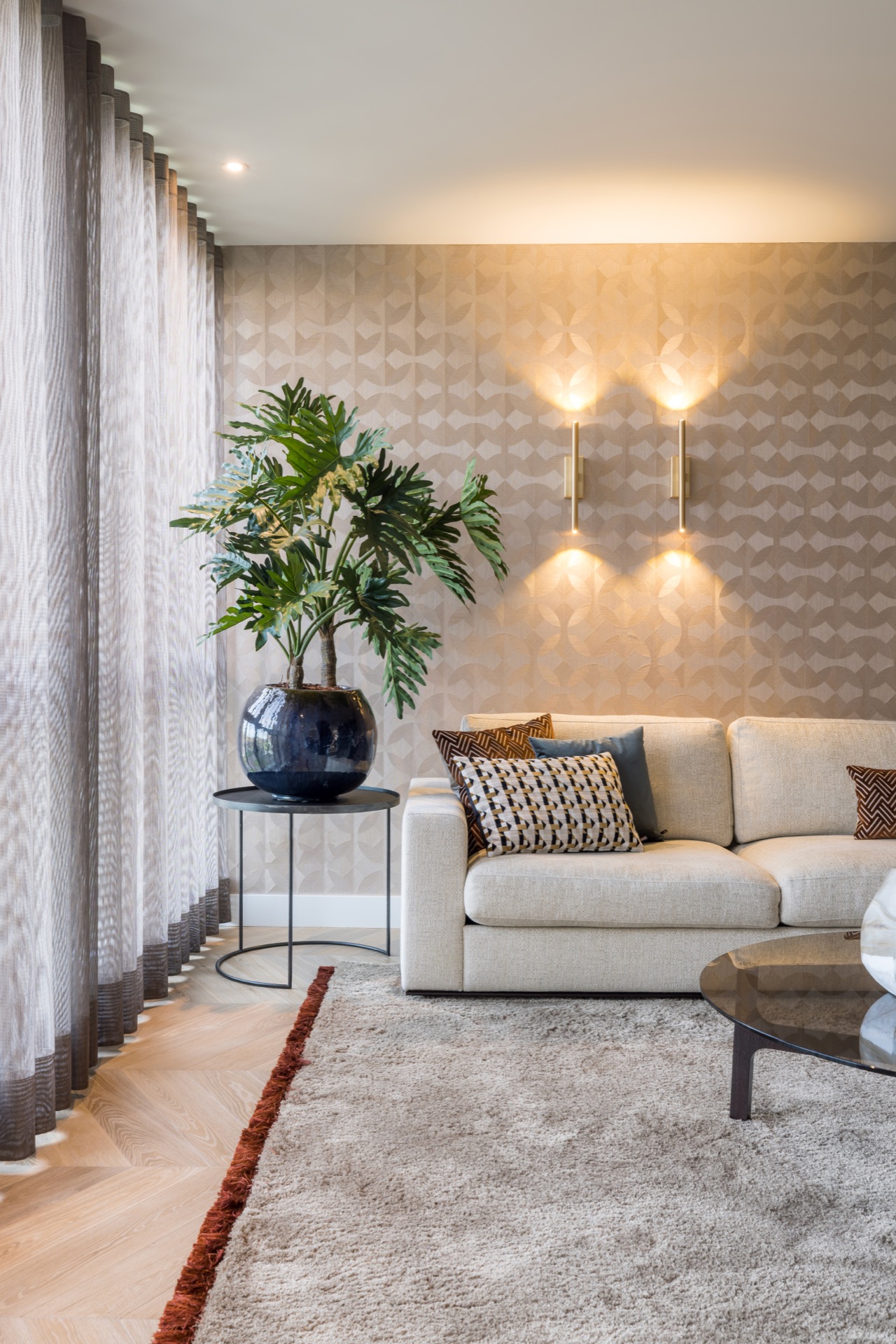 lampade da parete e sospensioni sottili: soggiorno con divano neutro, parete a motivo geometrico e luci verticali calde a, Luxury, Design, Exclusive, Modern, Custom Made, Special, Beautiful