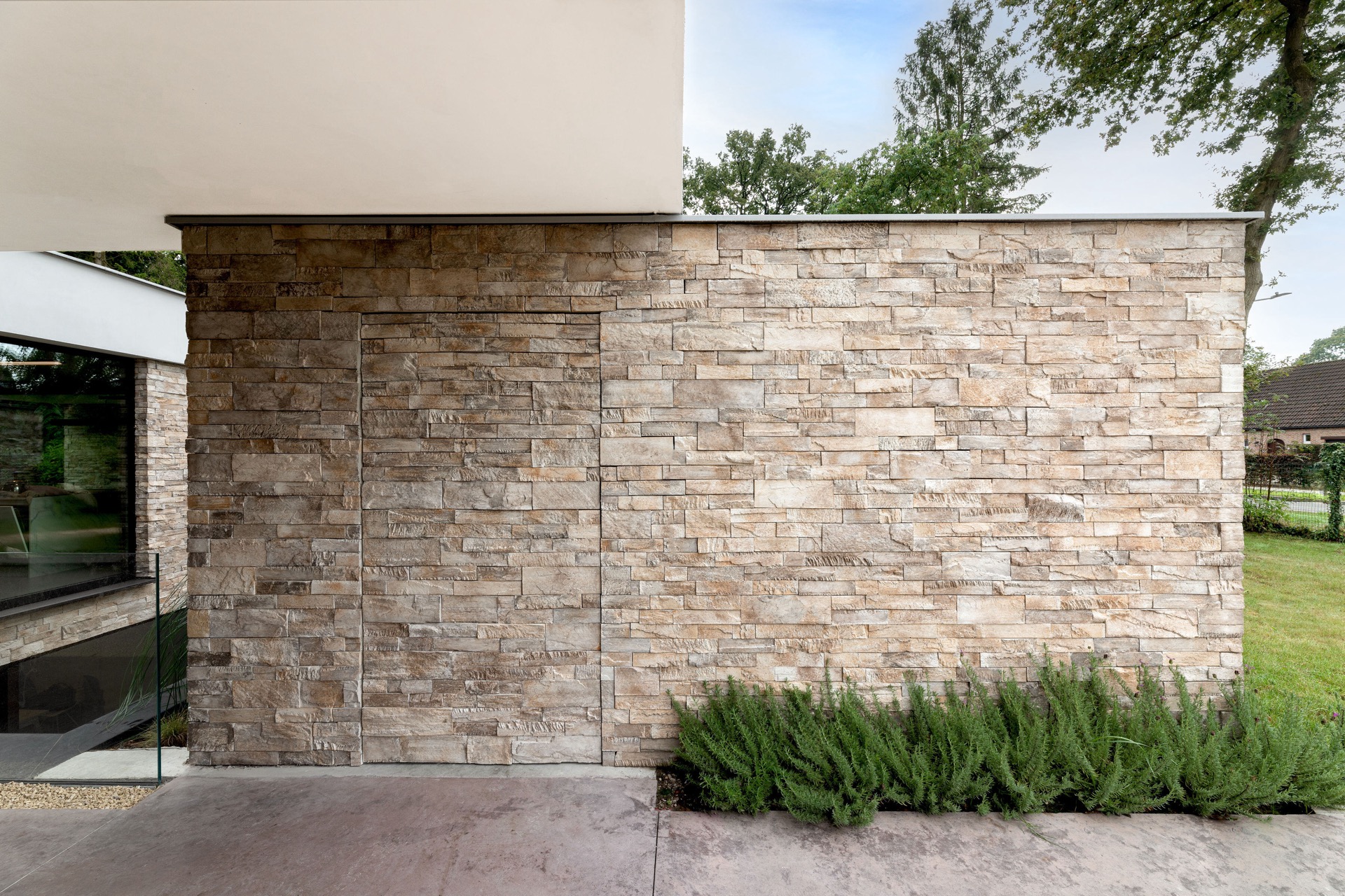 rivestimento in pietra naturale: muro in pietra naturale della villa con apertura vetrata nella facciata e verde davanti, Luxury, Design, Exclusive, Modern, Custom Made, Special, Beautiful