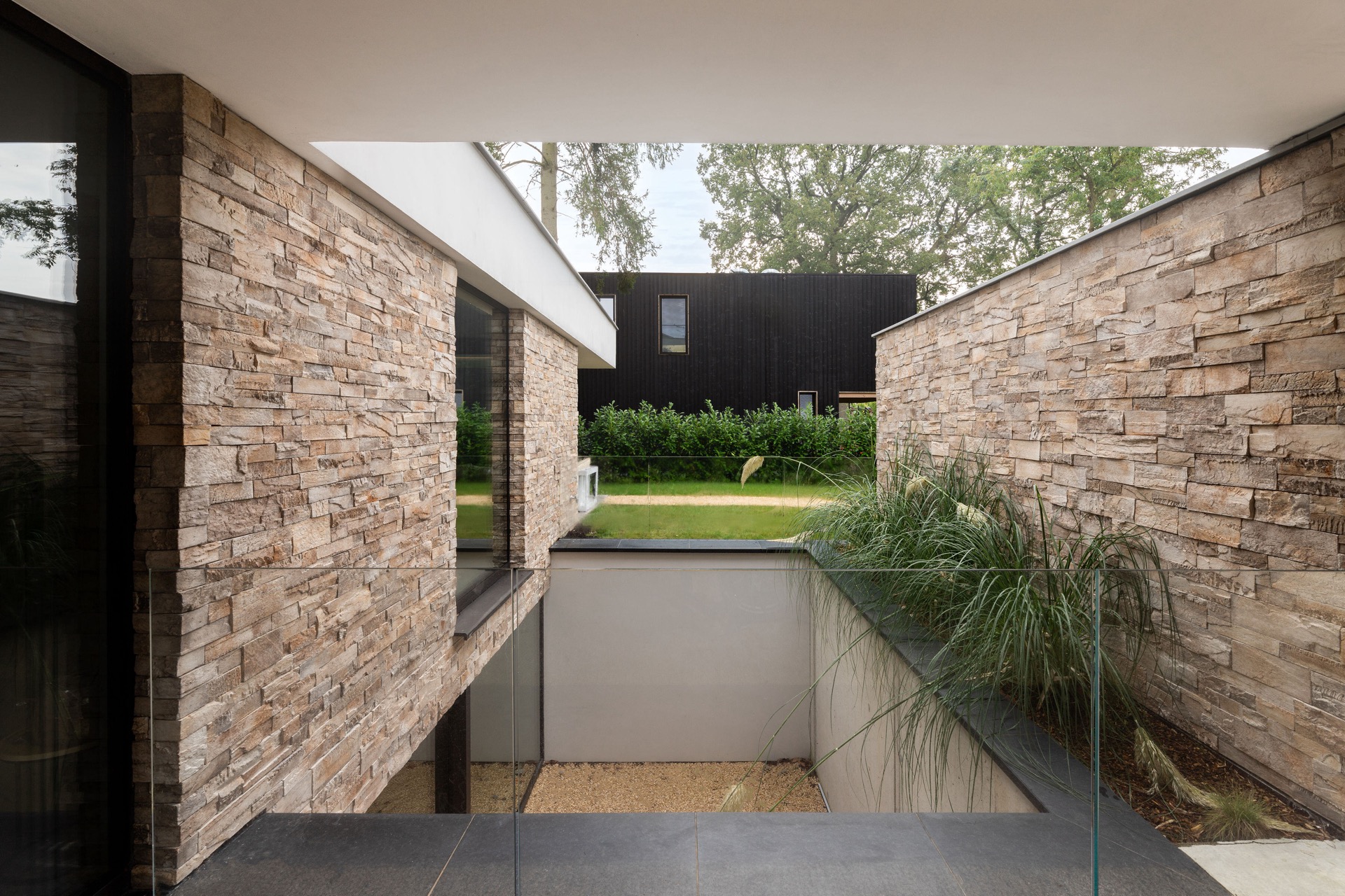 rivestimento in pietra naturale: vista della parete in pietra naturale con parapetto in vetro e area giardino, Luxury, Design, Exclusive, Modern, Custom Made, Special, Beautiful