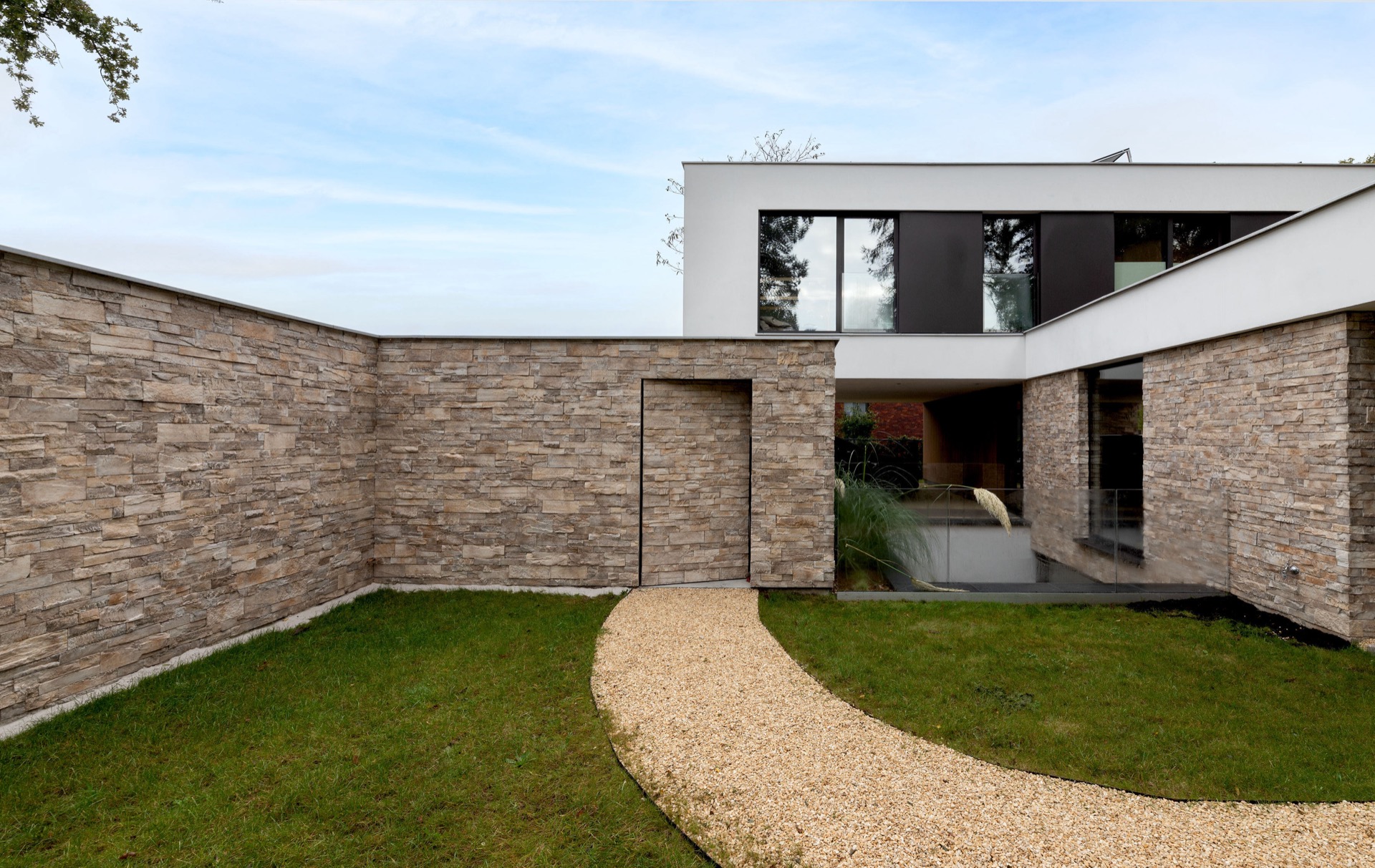 rivestimento in pietra naturale: cortile con pareti in pietra naturale, pannelli in vetro e percorso in ghiaia, Luxury, Design, Exclusive, Modern, Custom Made, Special, Beautiful
