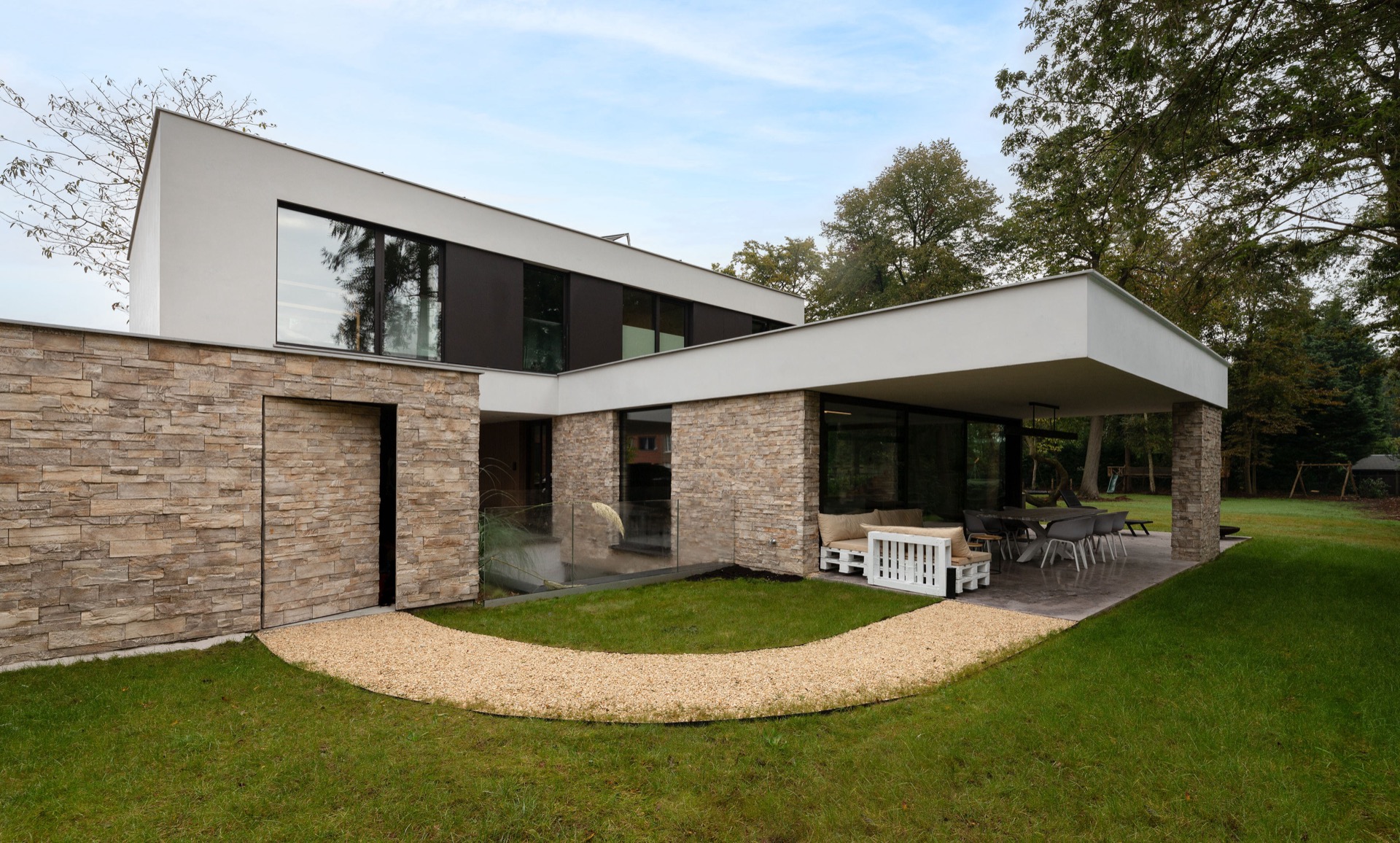rivestimento in pietra naturale: vista frontale di villa moderna con zoccolo in pietra naturale, grandi finestre e terrazza, Luxury, Design, Exclusive, Modern, Custom Made, Special, Beautiful