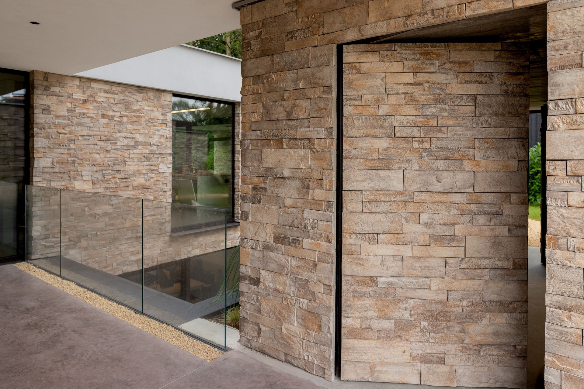 rivestimento in pietra naturale: vista di un cortile con pareti in pietra naturale e parapetto in vetro, Luxury, Design, Exclusive, Modern, Custom Made, Special, Beautiful