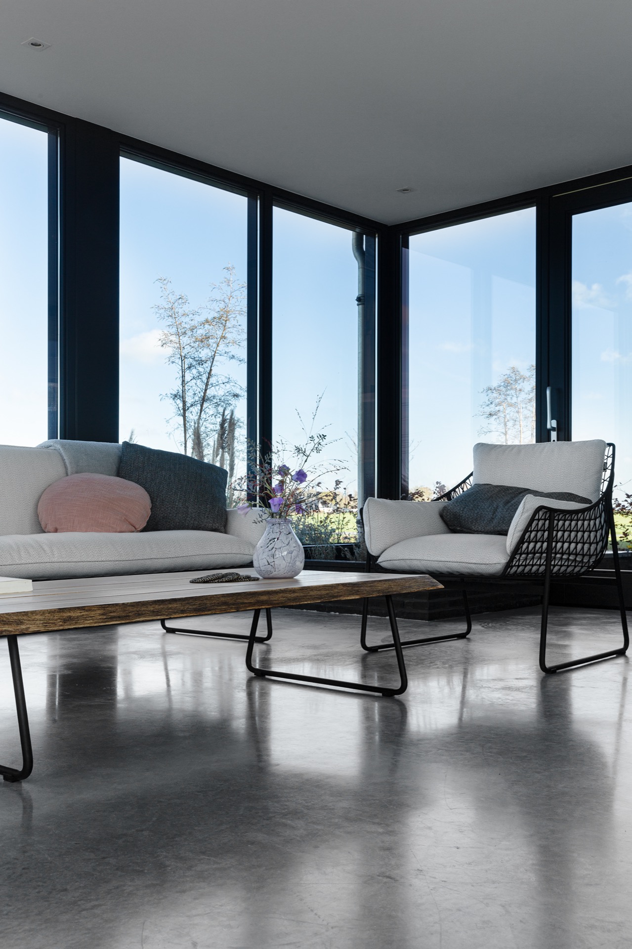 pareti in cemento decorativo: zona salotto con pavimento in cemento grigio e grande parete finestrata con telai neri, Luxury, Design, Exclusive, Modern, Custom Made, Special, Beautiful