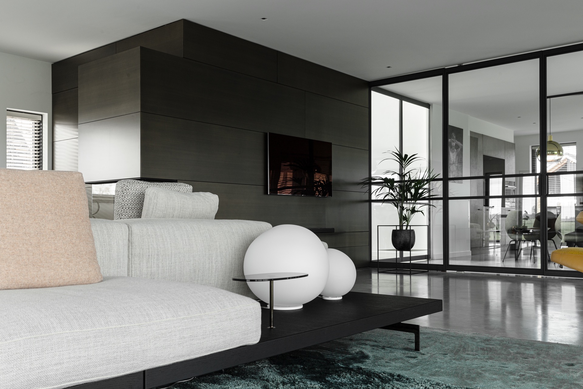 pareti in cemento decorativo: soggiorno con grande divisorio in vetro, pannelli scuri e pavimento in cemento grigio, Luxury, Design, Exclusive, Modern, Custom Made, Special, Beautiful