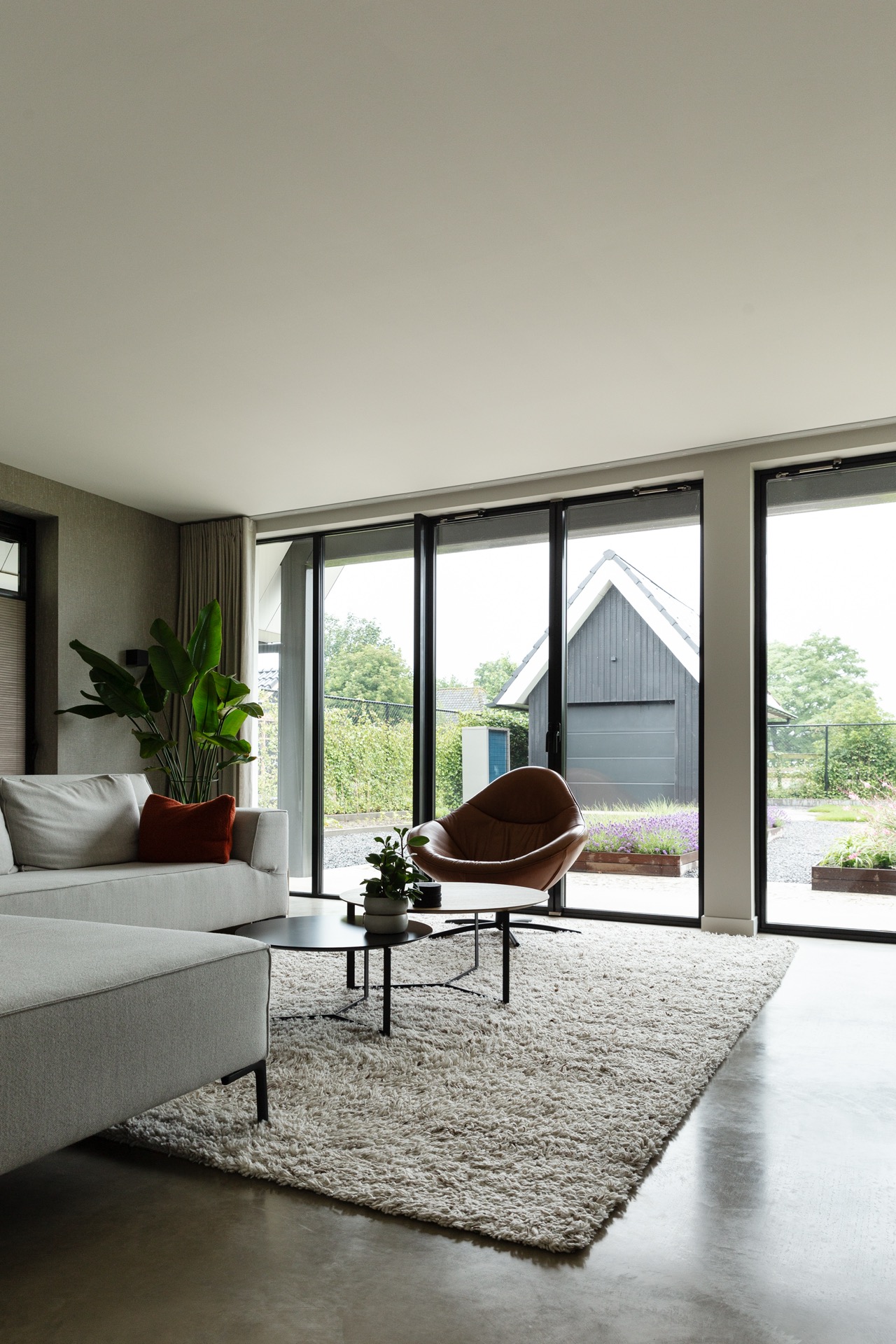 concrete floor in detached house: bright living room with large window and sliding doors to a concrete terrace, Luxury, Design, Exclusive, Modern, Custom Made, Special, Beautiful