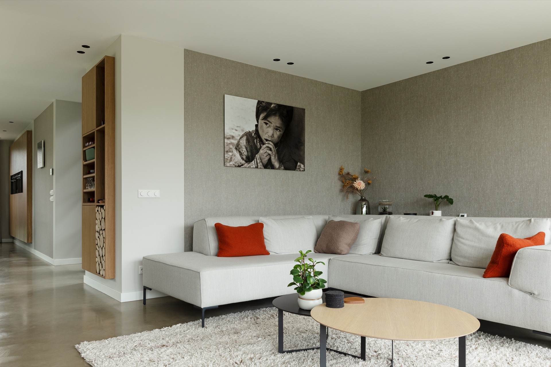 concrete floor in detached house: living area with sofa, textured wall panel, and wooden niche in a modern interior, Luxury, Design, Exclusive, Modern, Custom Made, Special, Beautiful