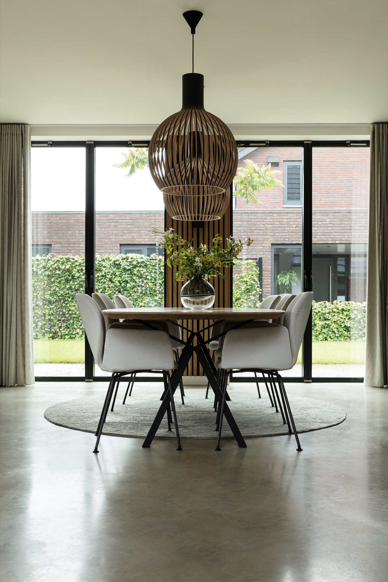 concrete floor in detached house: dining area with large glazing and a pendant light looking onto the terrace and garden, Luxury, Design, Exclusive, Modern, Custom Made, Special, Beautiful
