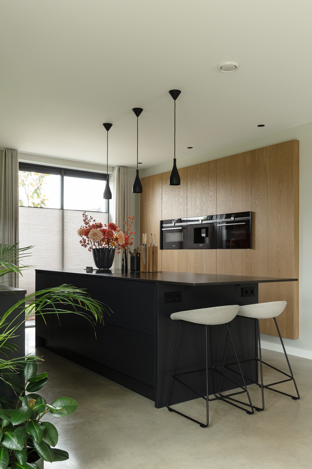concrete floor in detached house: kitchen wall with wood panels, dark fronts, and pendant lights over the countertop, Luxury, Design, Exclusive, Modern, Custom Made, Special, Beautiful