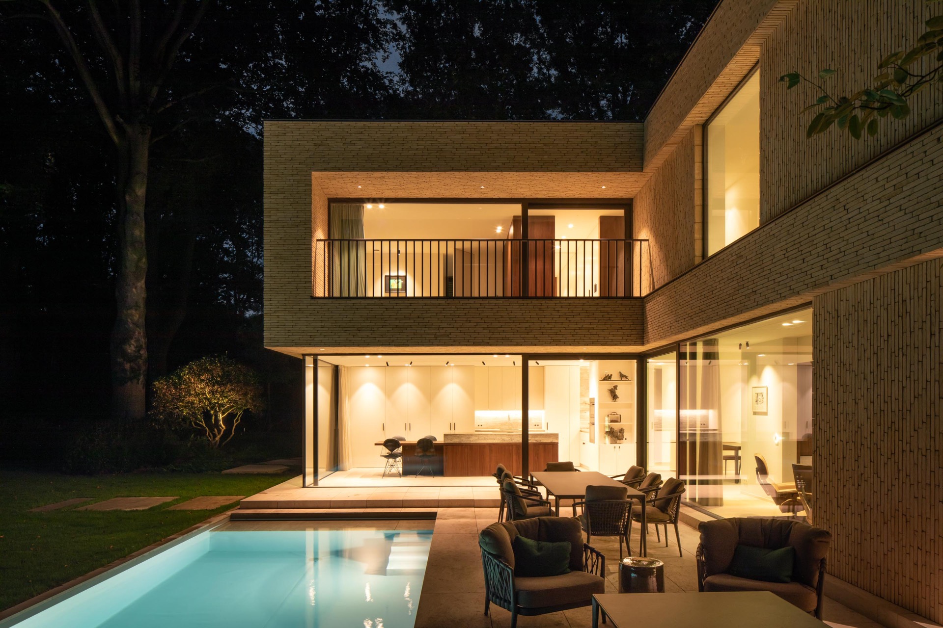 villa moderna in mattoni beige: vista serale di una villa beige con pensilina illuminata e grandi aperture in vetro, Luxury, Design, Exclusive, Modern, Custom Made, Special, Beautiful