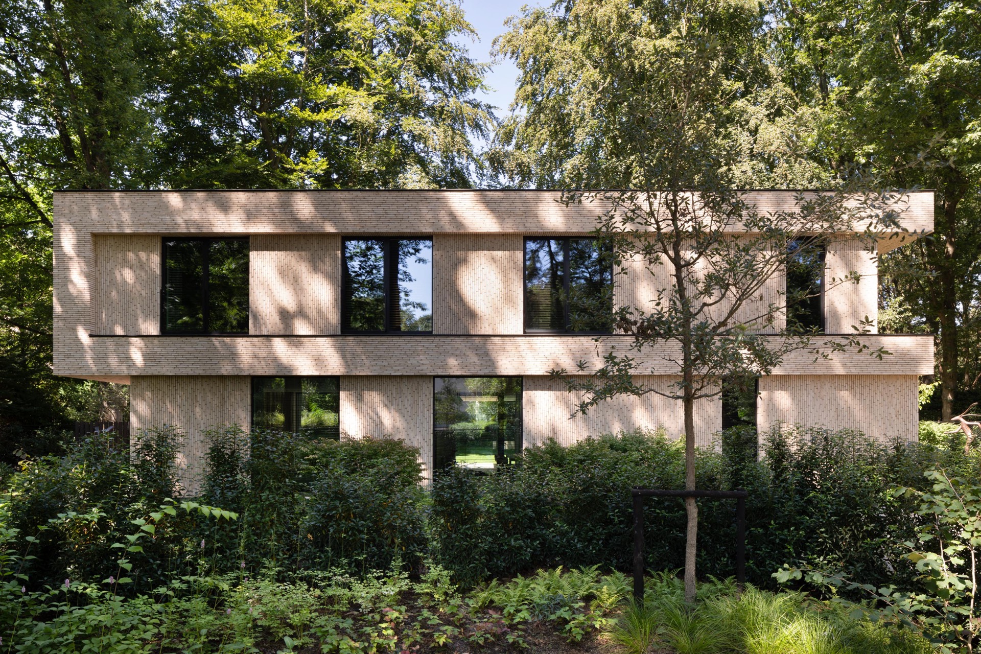 villa moderna in mattoni beige: esterno di villa moderna con facciata in mattoni beige e grandi finestre nel verde, Luxury, Design, Exclusive, Modern, Custom Made, Special, Beautiful