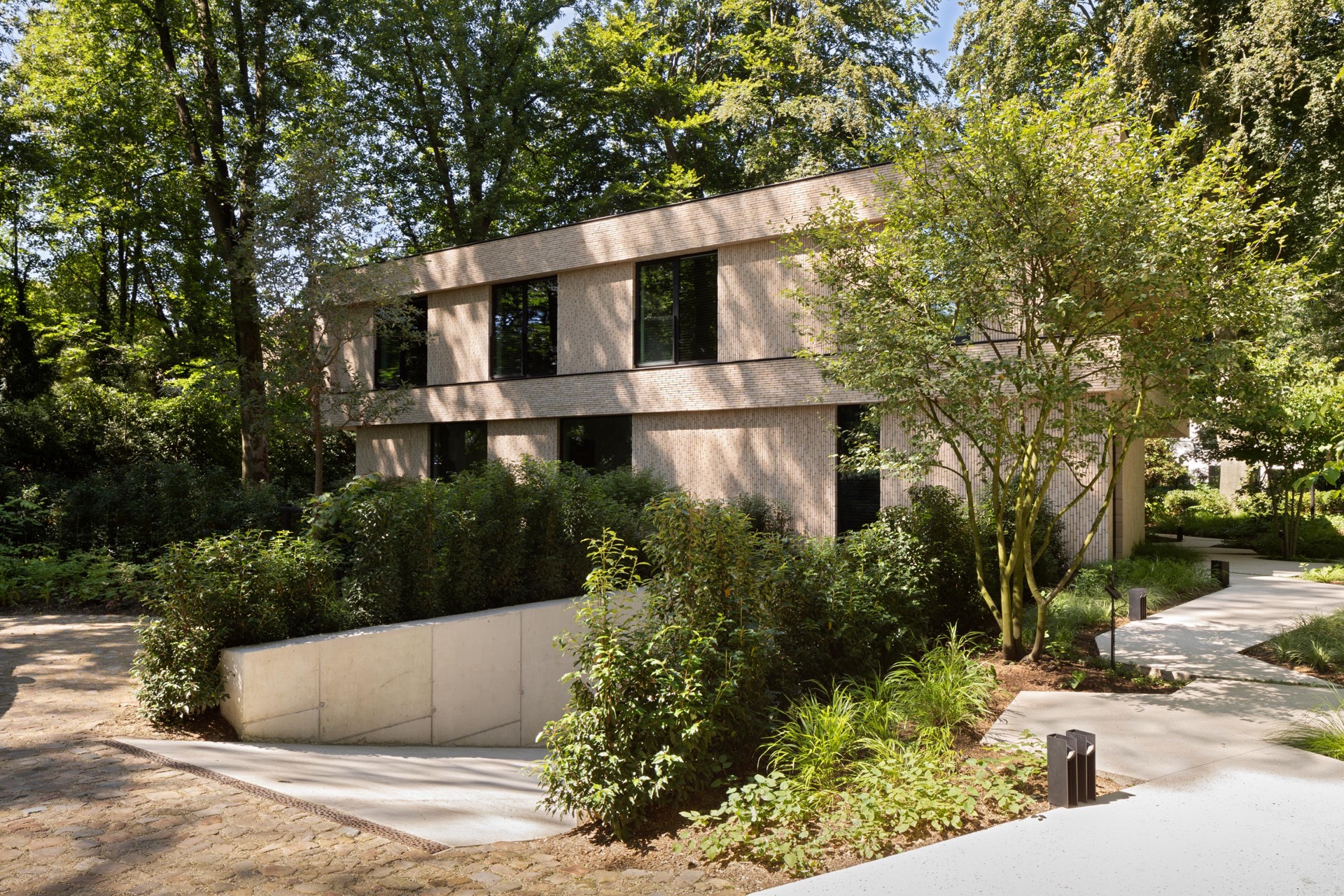 villa moderna in mattoni beige: facciata di villa beige con vialetto in giardino e grandi finestre tra gli alberi, Luxury, Design, Exclusive, Modern, Custom Made, Special, Beautiful