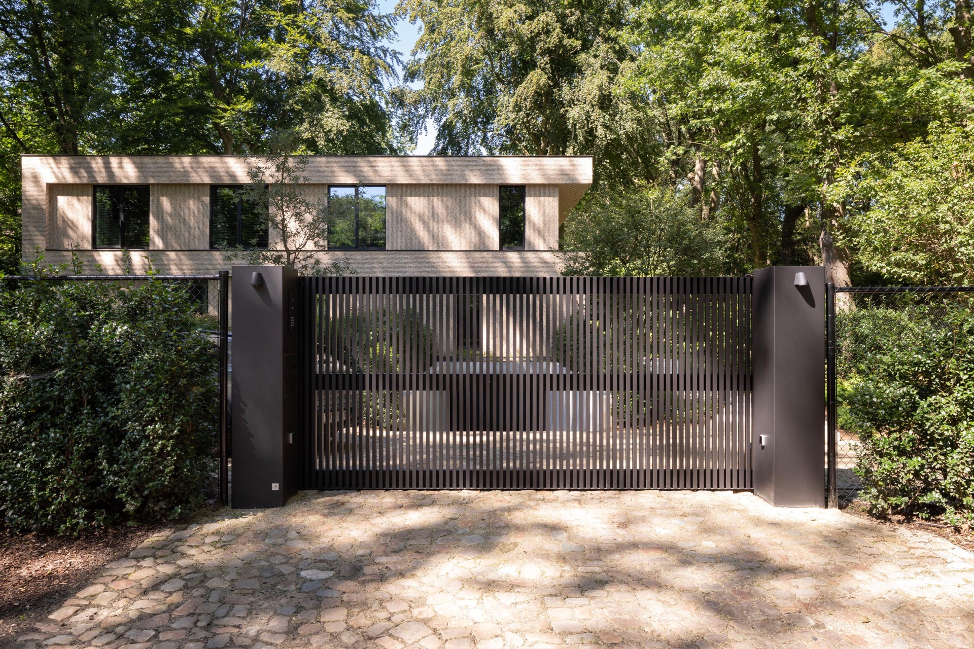 villa moderna in mattoni beige: villa moderna con facciata in mattoni beige dietro un cancello metallico scuro, Luxury, Design, Exclusive, Modern, Custom Made, Special, Beautiful