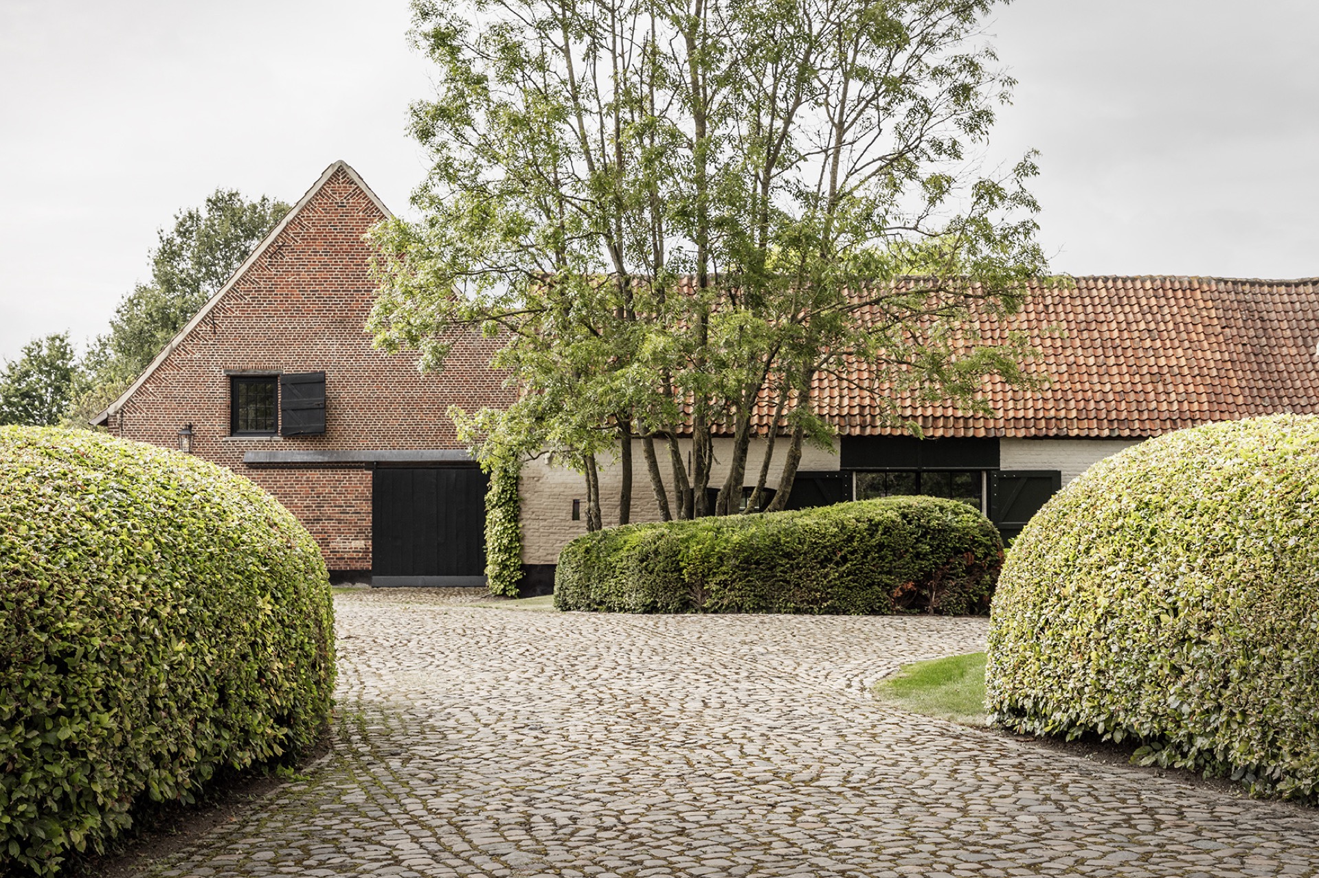 landscape garden sightline: outbuilding facade with dark doors and a cobblestone walkway in the garden, Luxury, Design, Exclusive, Modern, Custom Made, Special, Beautiful