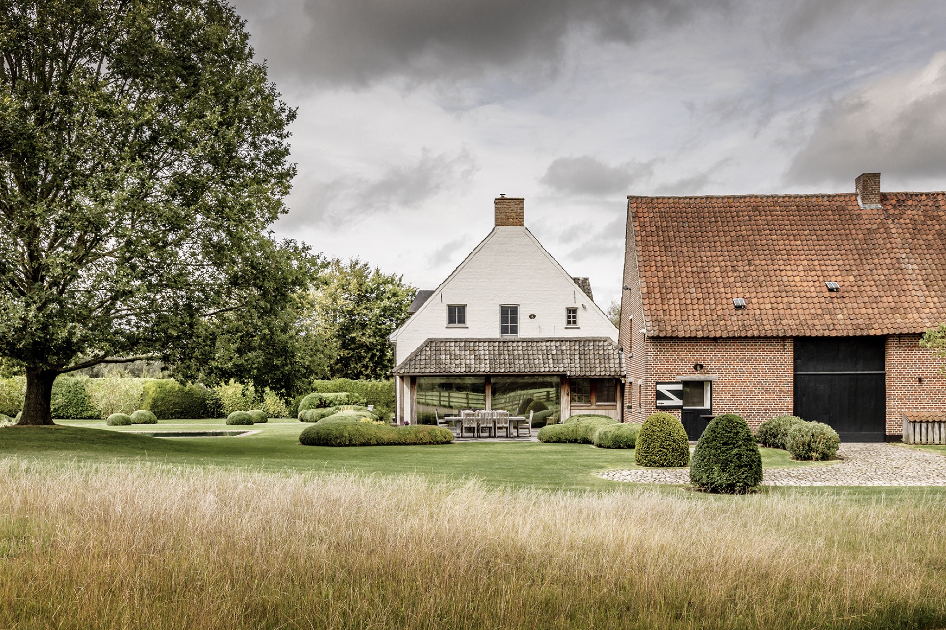 landscape garden sightline: view of the farm buildings with lawn, round trimmed hedges and terrace, Luxury, Design, Exclusive, Modern, Custom Made, Special, Beautiful