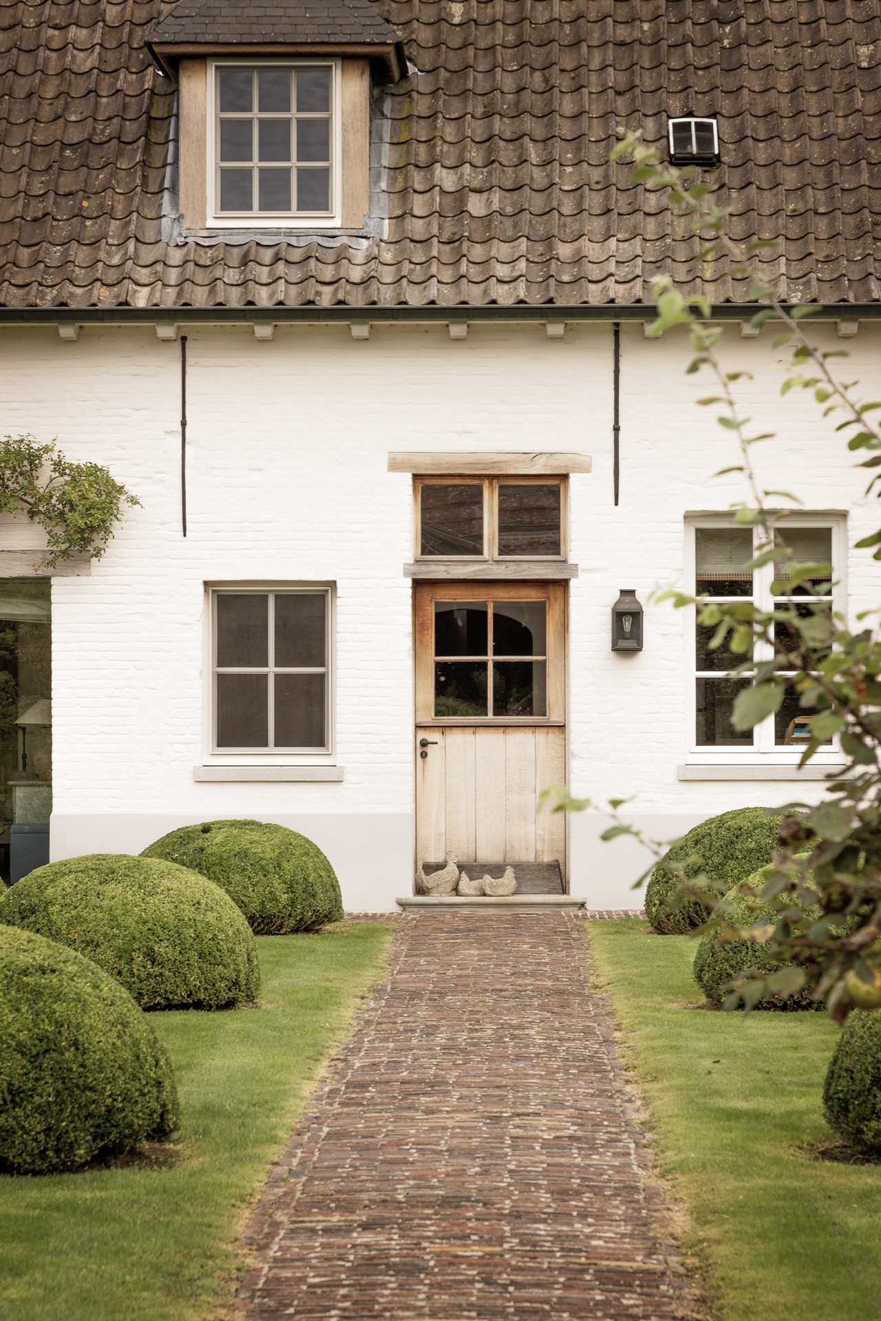 landscape garden sightline: facade detail with red roof tiles, windows and a path to the entrance door, Luxury, Design, Exclusive, Modern, Custom Made, Special, Beautiful