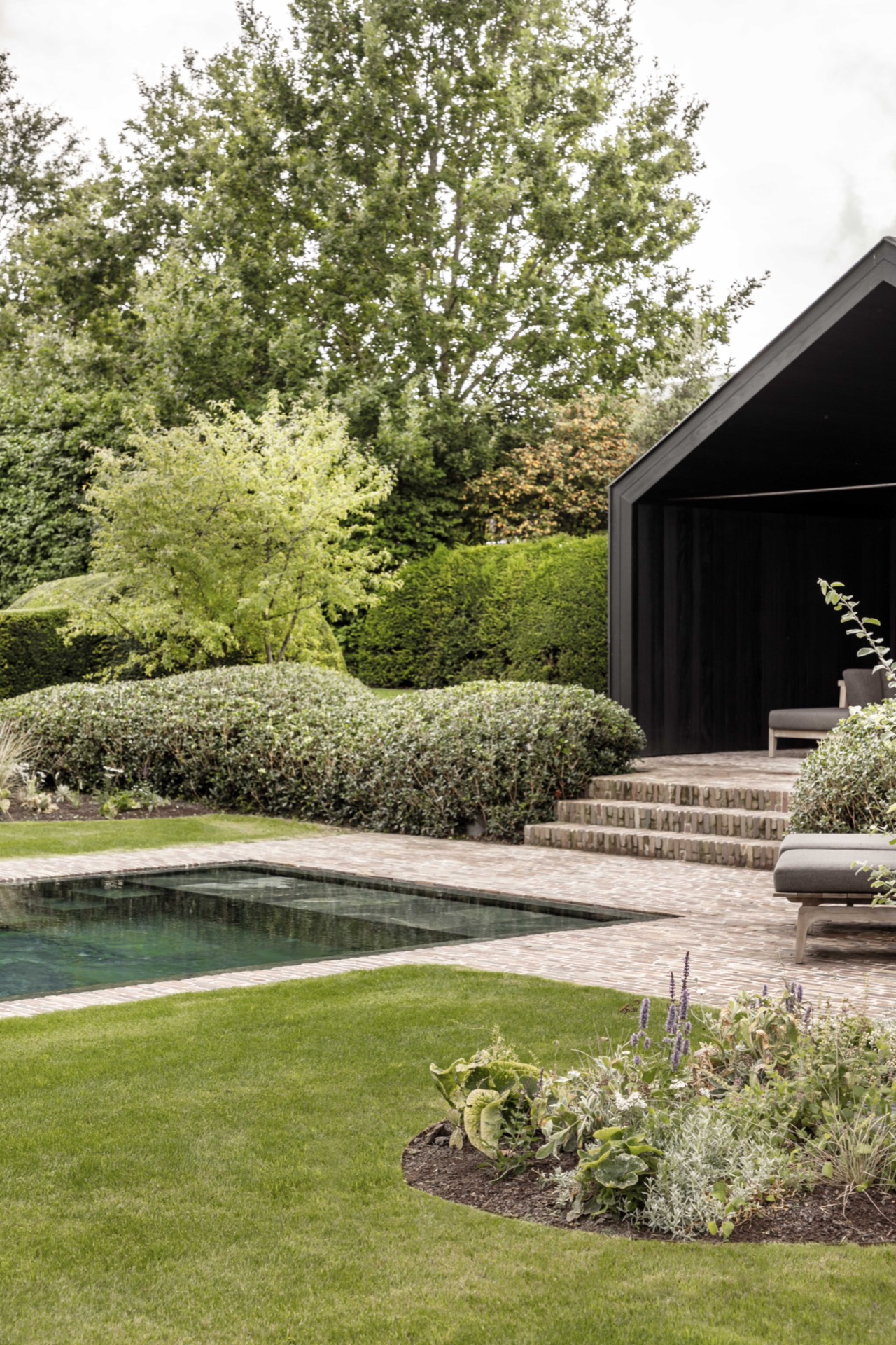 landscape garden sightline: side facade with dark panel and a garden walkway among plants and lawn, Luxury, Design, Exclusive, Modern, Custom Made, Special, Beautiful