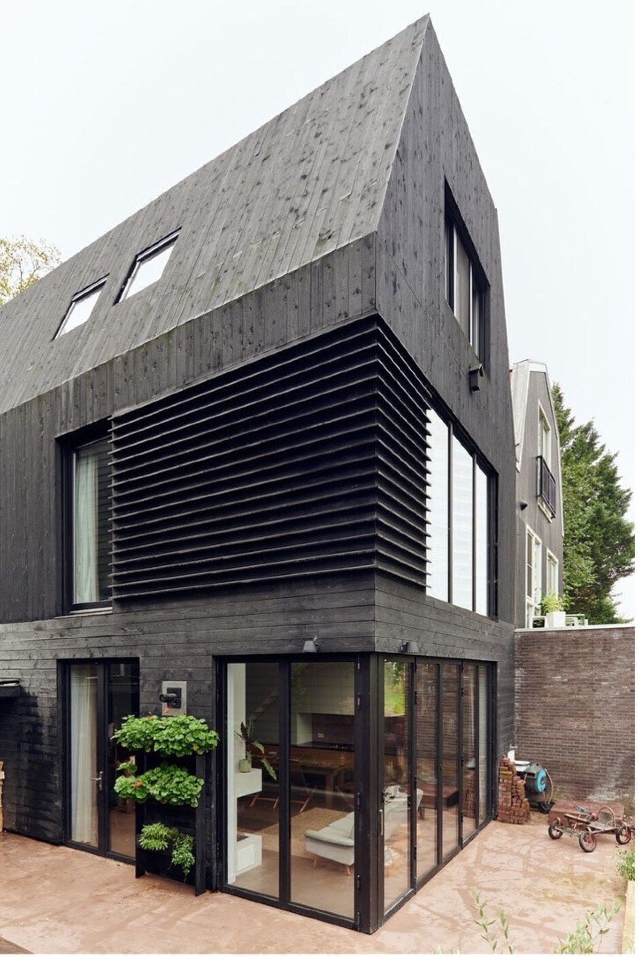indoor-outdoor connection home: dark timber facade with large glass sliding doors and a terrace on the garden side, Luxe, Design, Exclusief, Modern, Maatwerk, Bijzondere, Mooie
