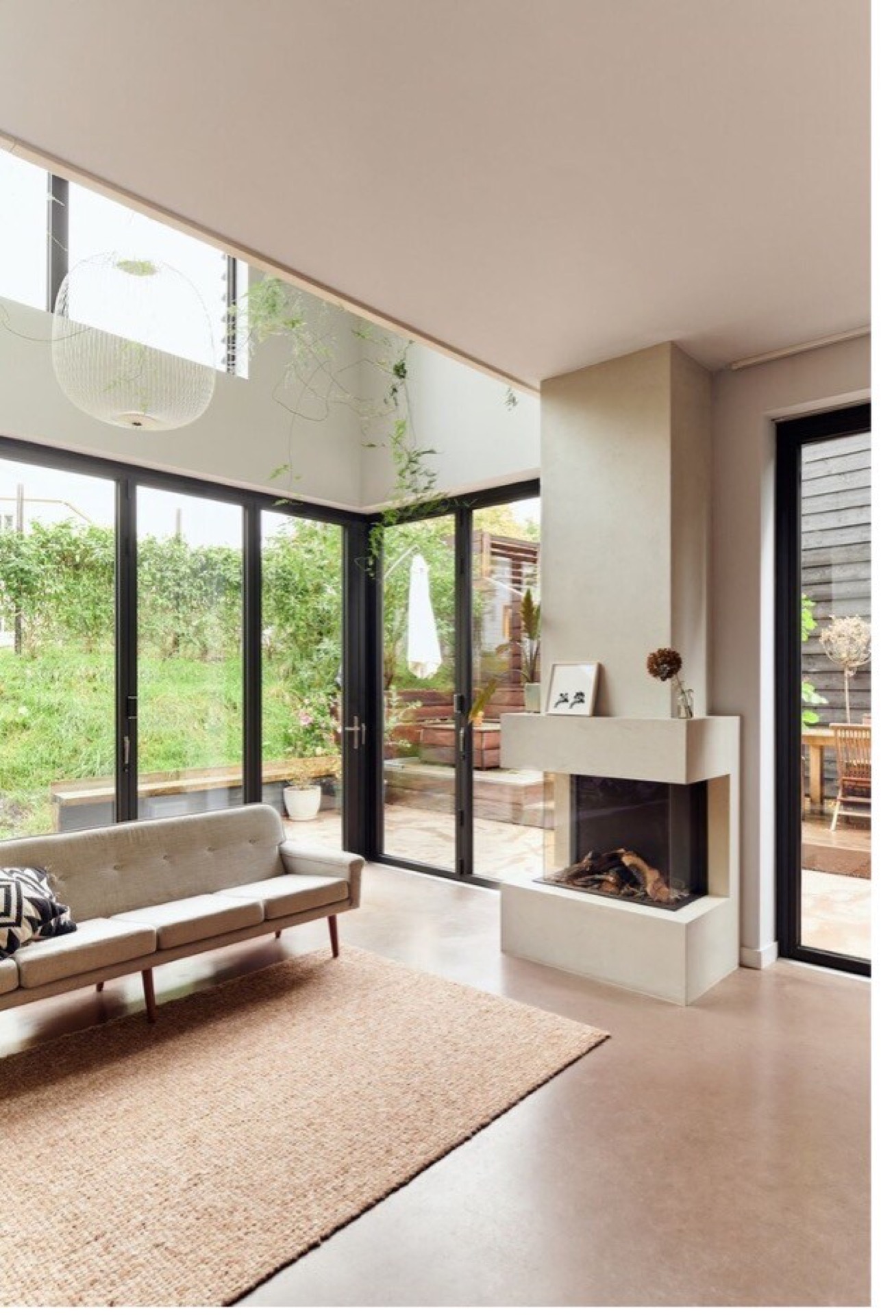 indoor-outdoor connection home: living room with fireplace wall and large glass doors opening to the terrace and garden, Luxe, Design, Exclusief, Modern, Maatwerk, Bijzondere, Mooie
