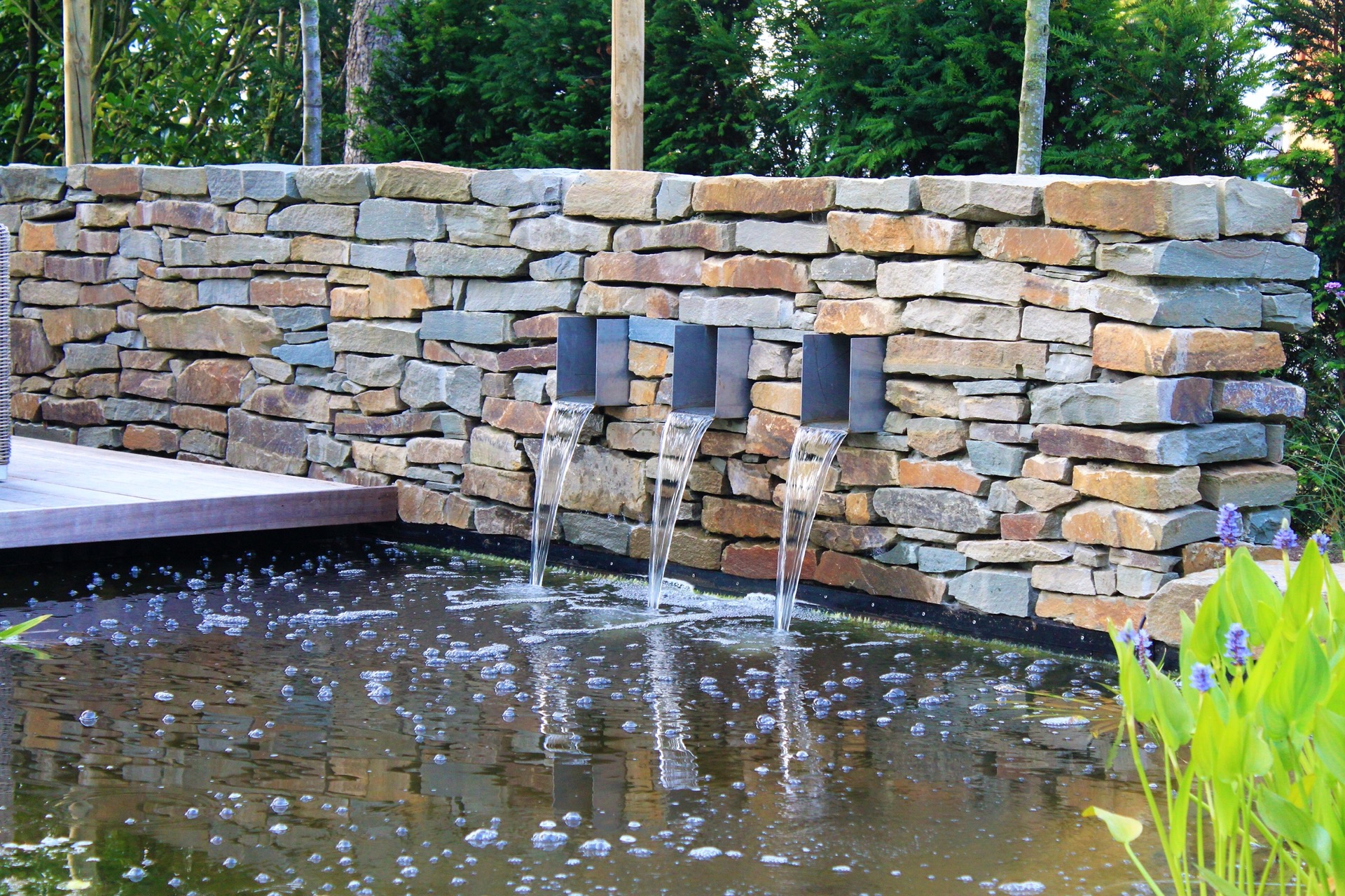 giardino moderno con laghetto e cascata: area relax vicino al laghetto con pavimentazione rettilinea e parete in pietra, Luxury, Design, Exclusive, Modern, Custom Made, Special, Beautiful