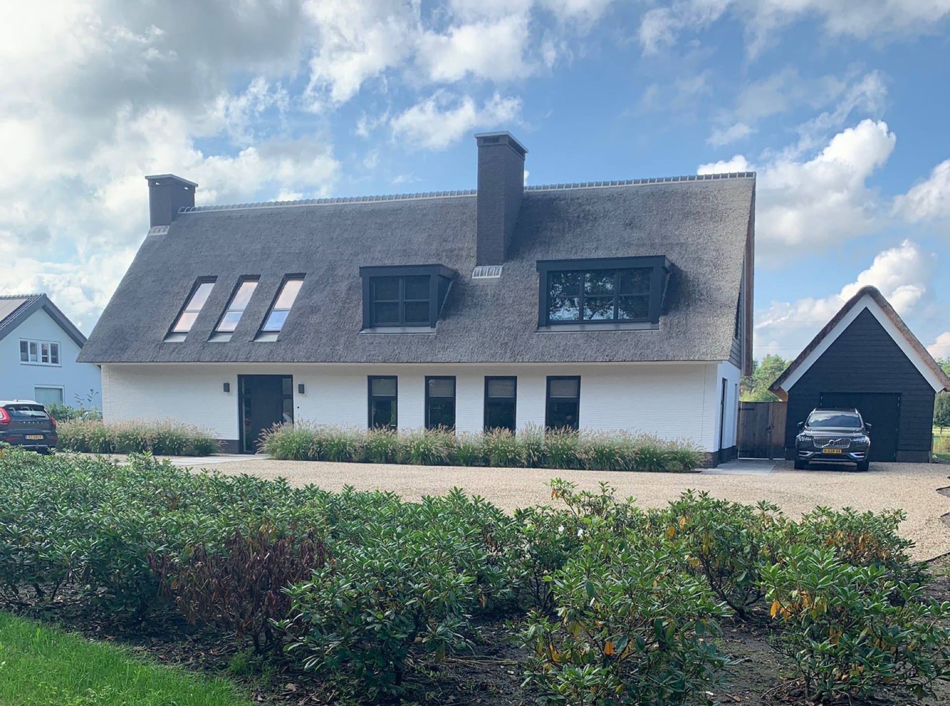 Country villa with thatched roof, white facade and black windows seen from the driveway area, Luxe, Design, Exclusief, Modern, Maatwerk, Bijzondere, Mooie