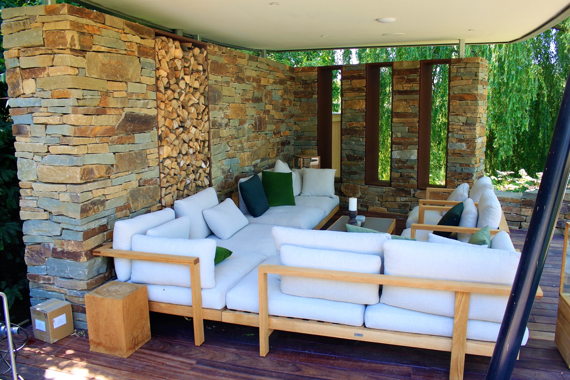 vasca da nuoto naturale con cascata: zona relax sotto un tettuccio con divano grande e parete in pietra naturale nel, Luxury, Design, Exclusive, Modern, Custom Made, Special, Beautiful