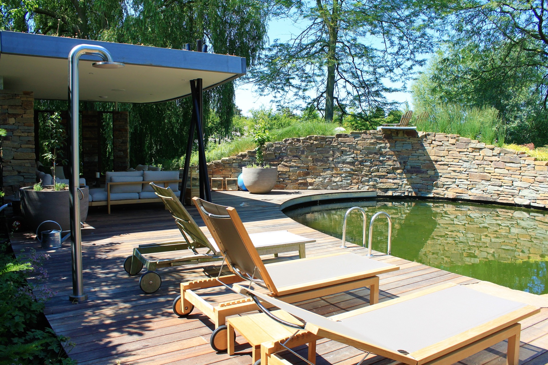vasca da nuoto naturale con cascata: cascata che scende da una parete in pietra naturale verso l’acqua della vasca, Luxury, Design, Exclusive, Modern, Custom Made, Special, Beautiful