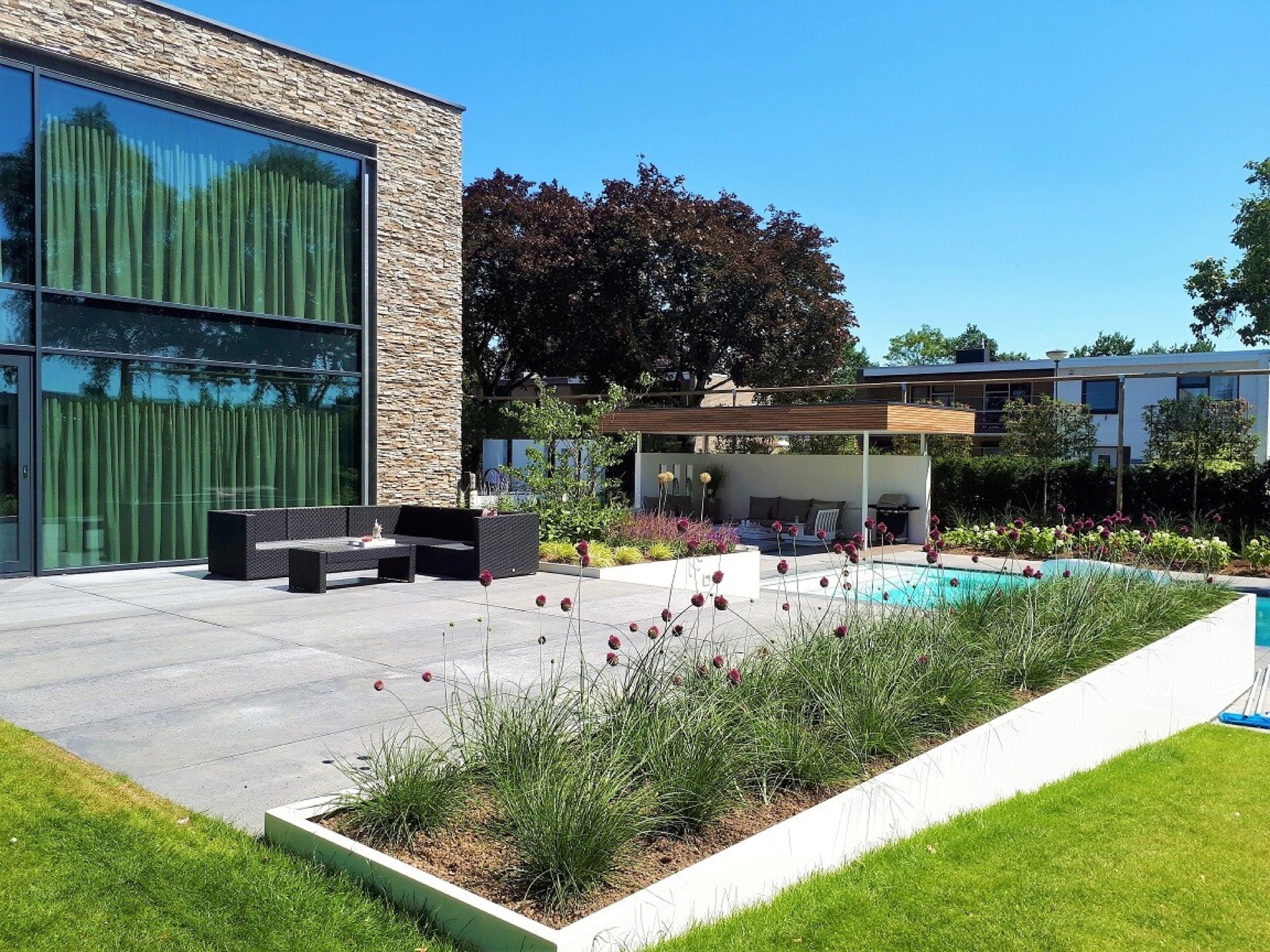 giardino moderno con piscina: vista laterale di giardino moderno con terrazza, bordure verdi e scorcio della piscina, Luxury, Design, Exclusive, Modern, Custom Made, Special, Beautiful