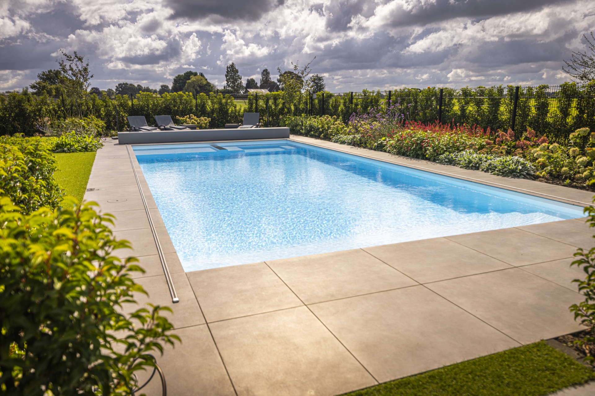 piscina rettangolare moderna con scala d’ingresso larga e zona lounge: vista laterale di piscina moderna con rivestimento, Luxury, Design, Exclusive, Modern, Custom Made, Special, Beautiful