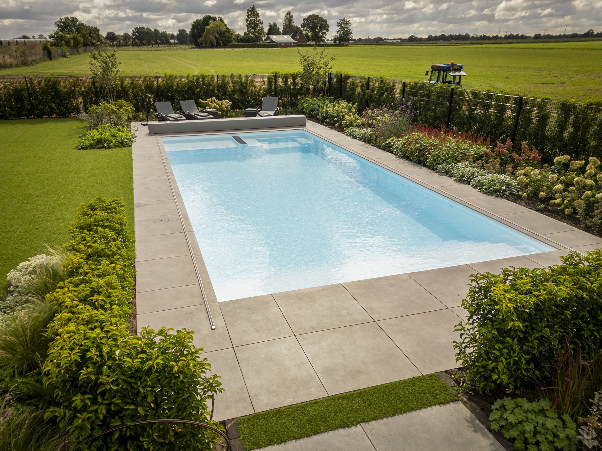 piscina rettangolare moderna con scala d’ingresso larga e zona lounge: vista laterale di piscina moderna con scalino, Luxury, Design, Exclusive, Modern, Custom Made, Special, Beautiful