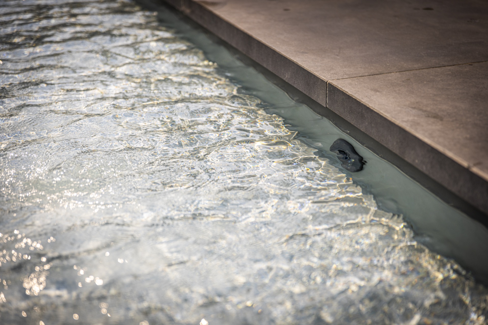 piscina incassata moderna con sistema di copertura: primo piano dell’acqua della piscina incassata con riflessi e parete in, Luxury, Design, Exclusive, Modern, Custom Made, Special, Beautiful